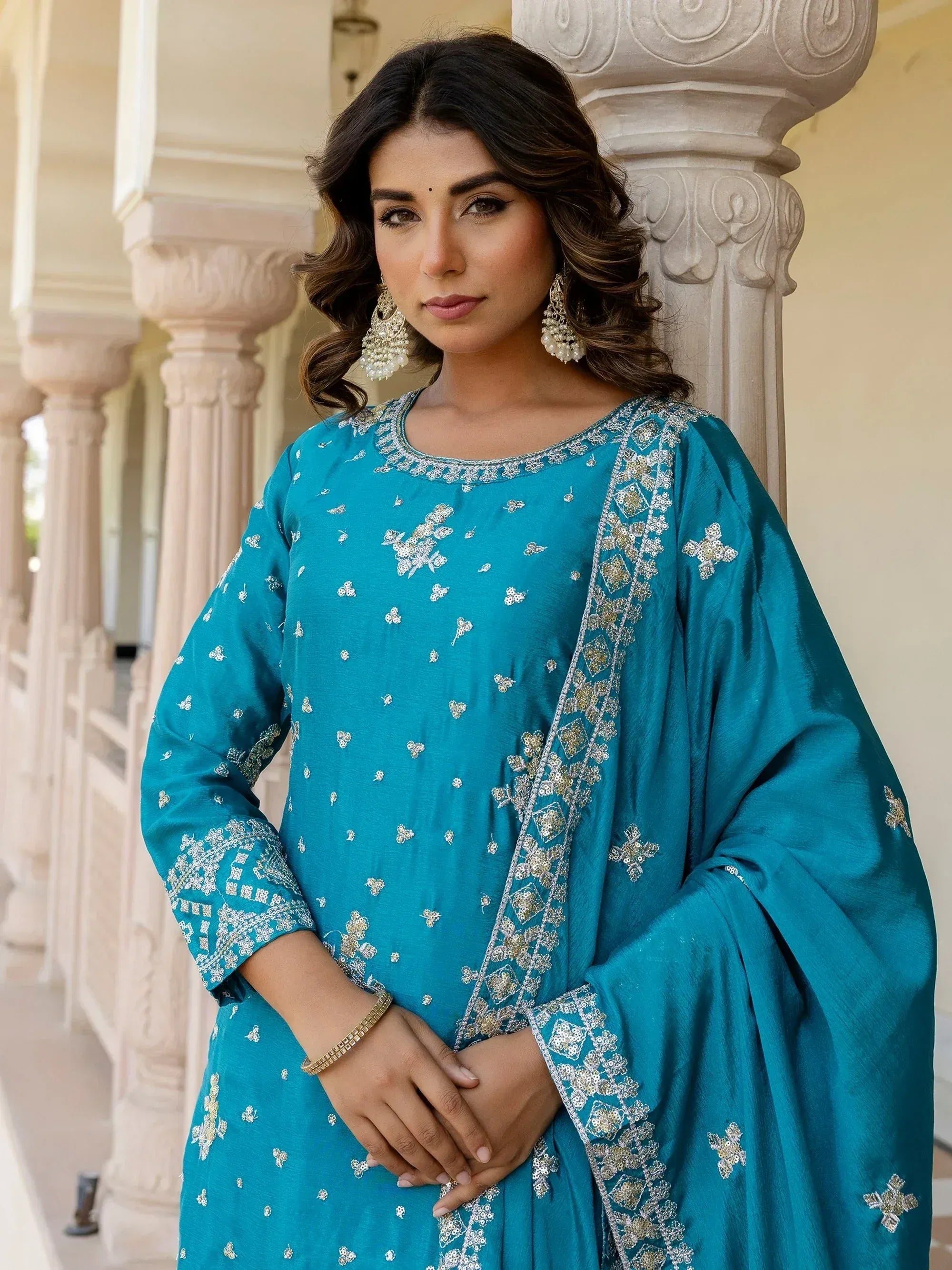 Teal embroidered salwar kameez with intricate floral designs and elegant drape