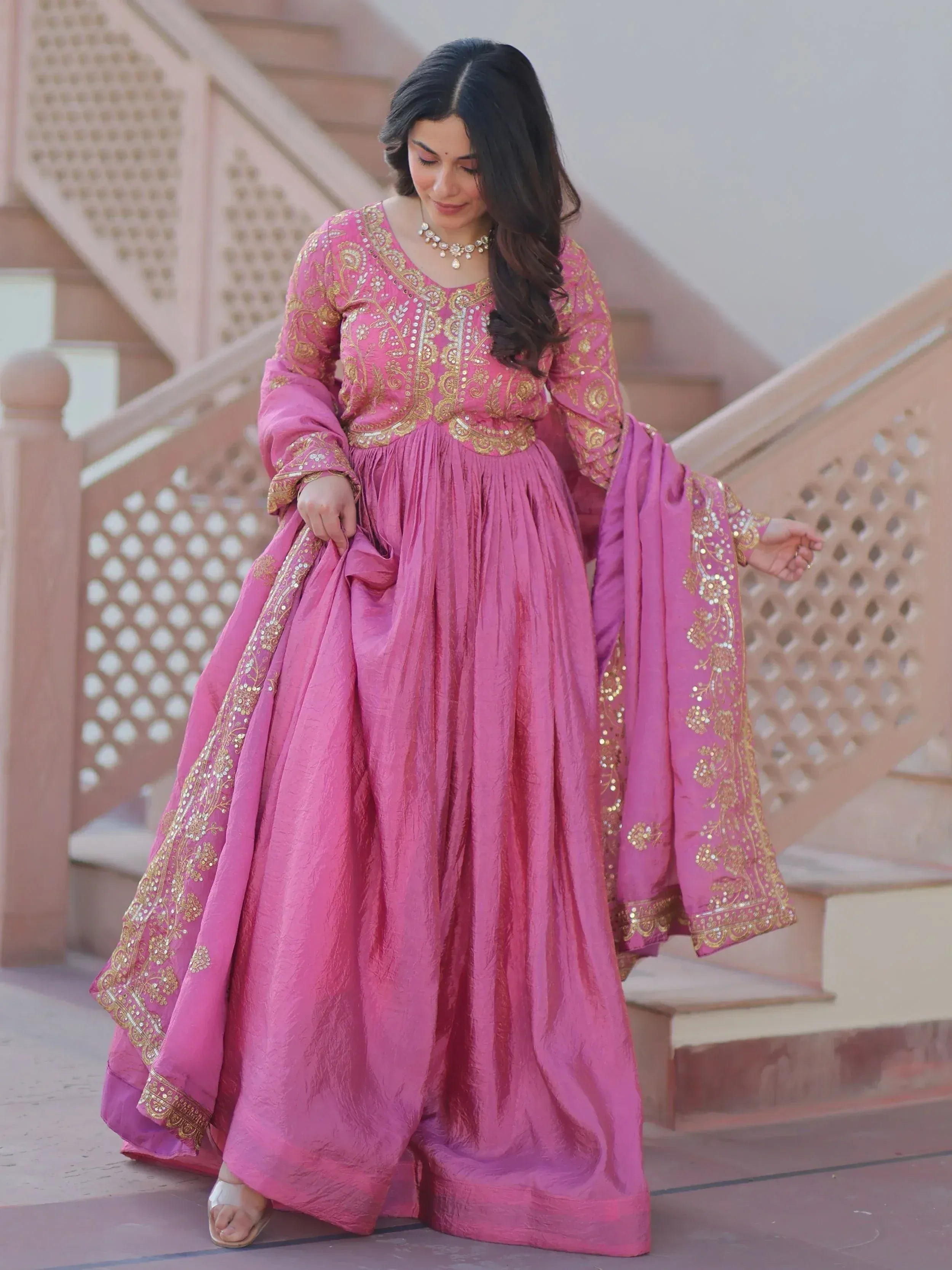 Pink embroidered ethnic gown with gold detailing, perfect for Indian celebrations and festive occasions.