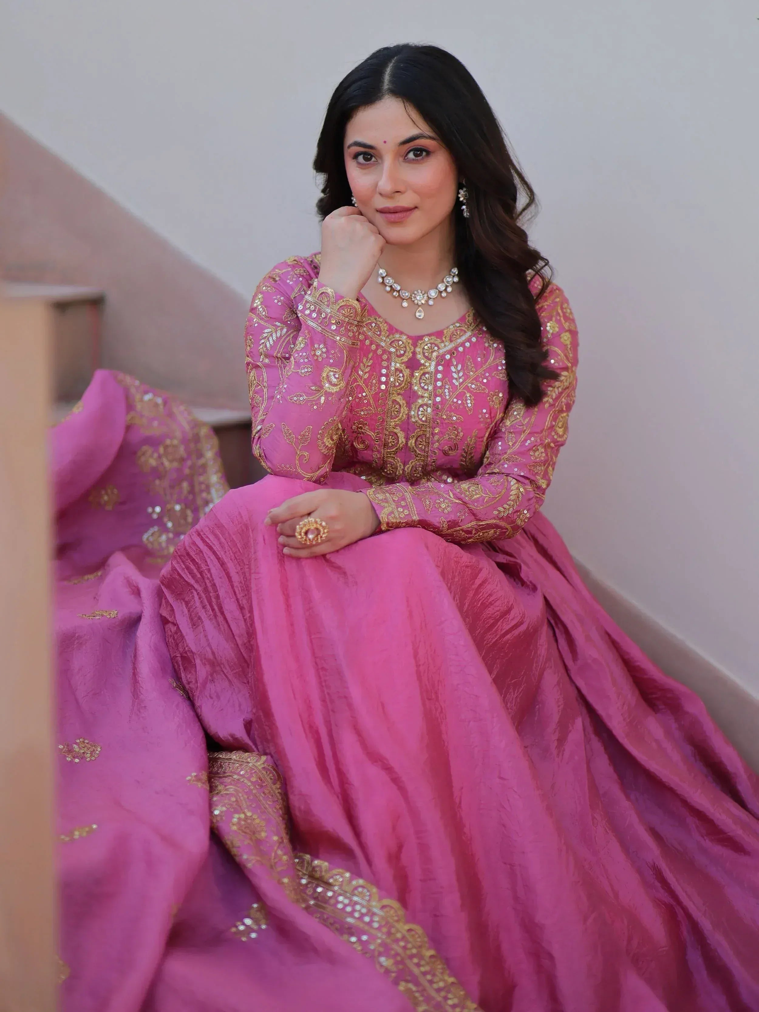 Woman in pink designer lehenga choli with gold embroidery, ethnic Indian wear for weddings and festivals