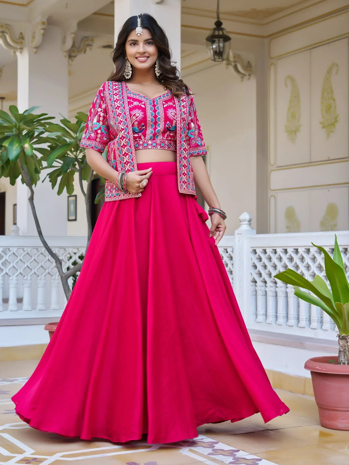 Woman in vibrant pink embroidered lehenga choli, perfect for Indian ethnic wear occasions