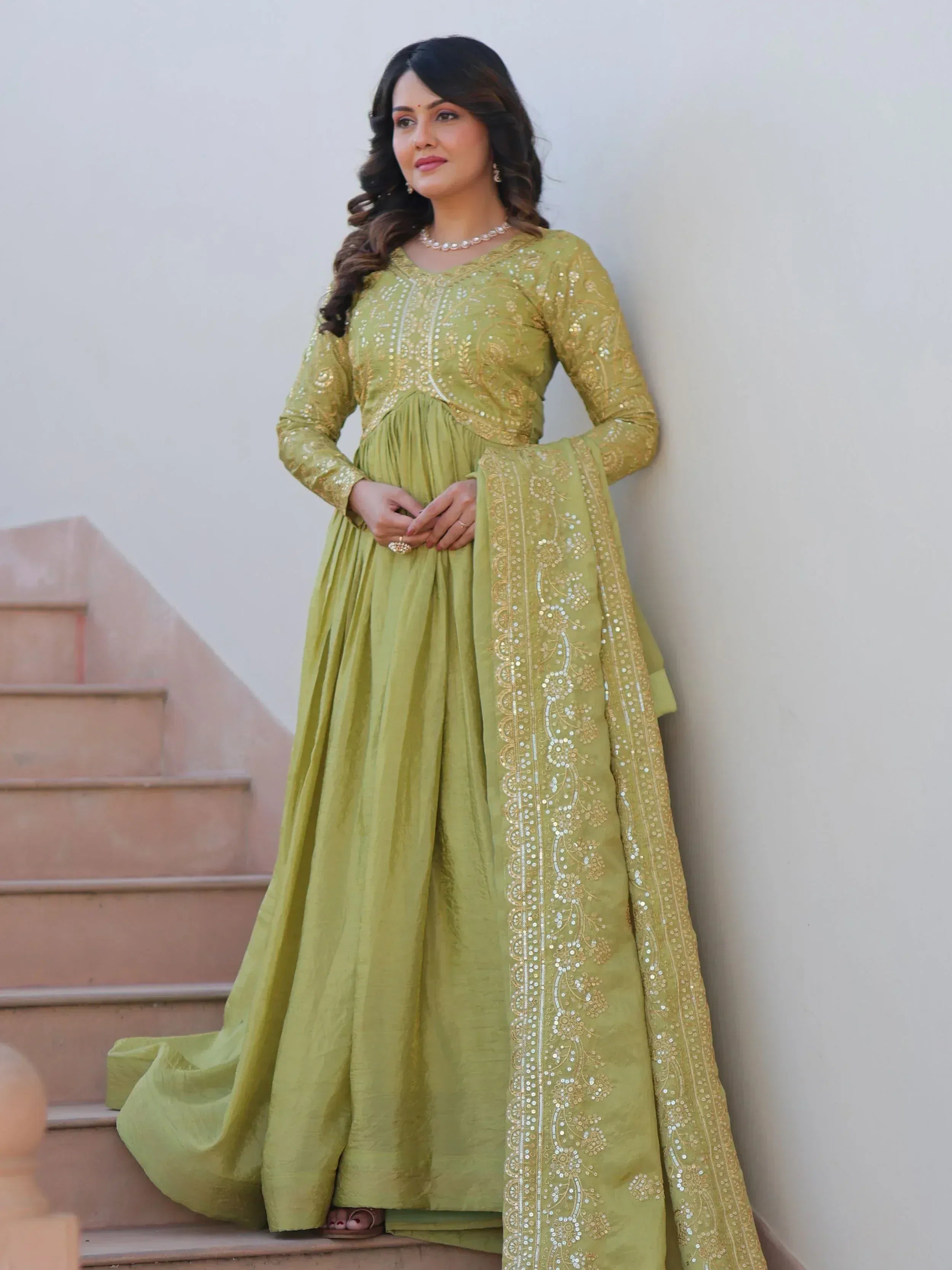Woman in olive green embroidered anarkali suit with gold sequin work, perfect for Indian ethnic occasions