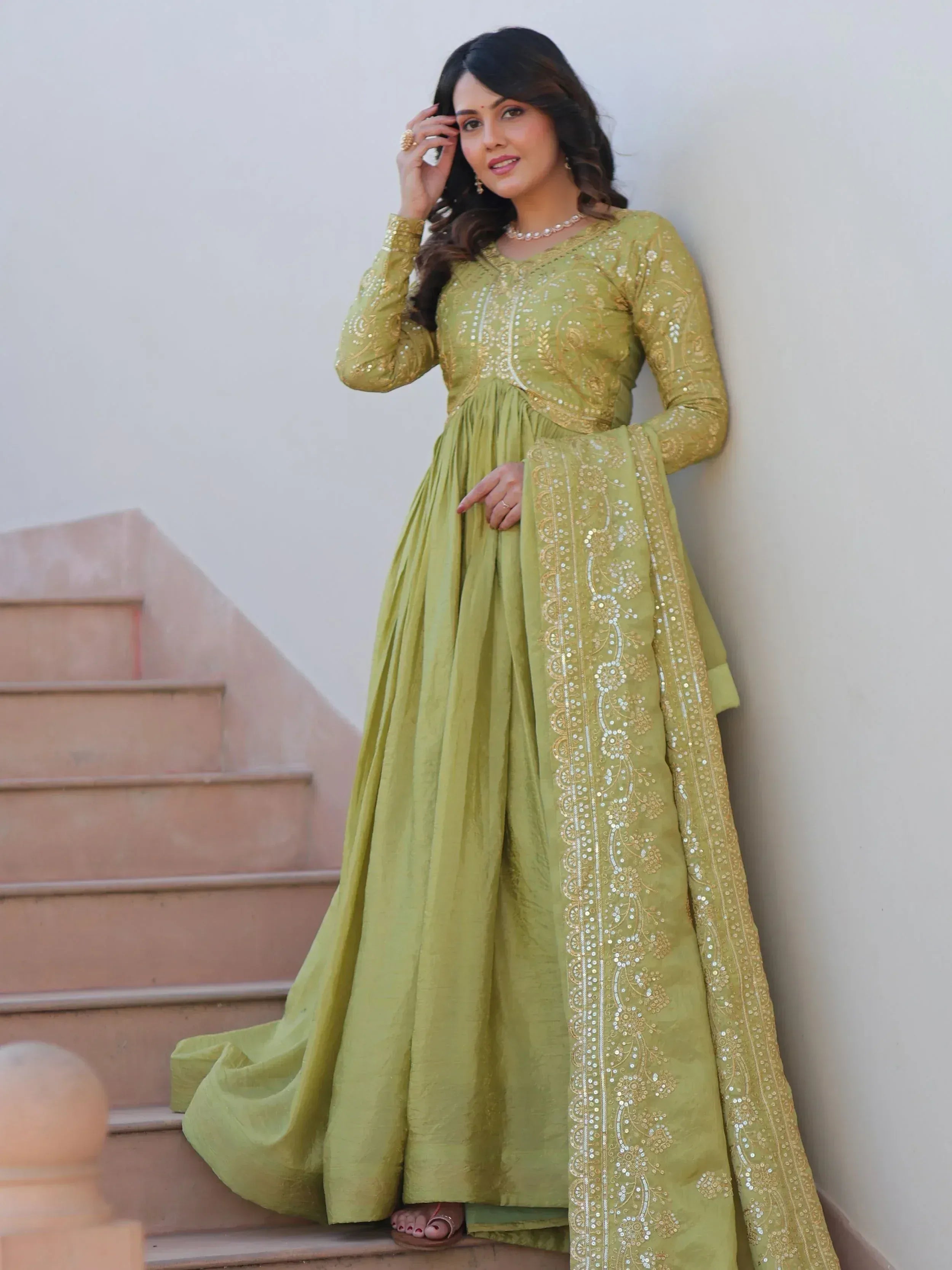 Woman in olive green embroidered anarkali suit with gold sequins, perfect for Indian ethnic wear occasions