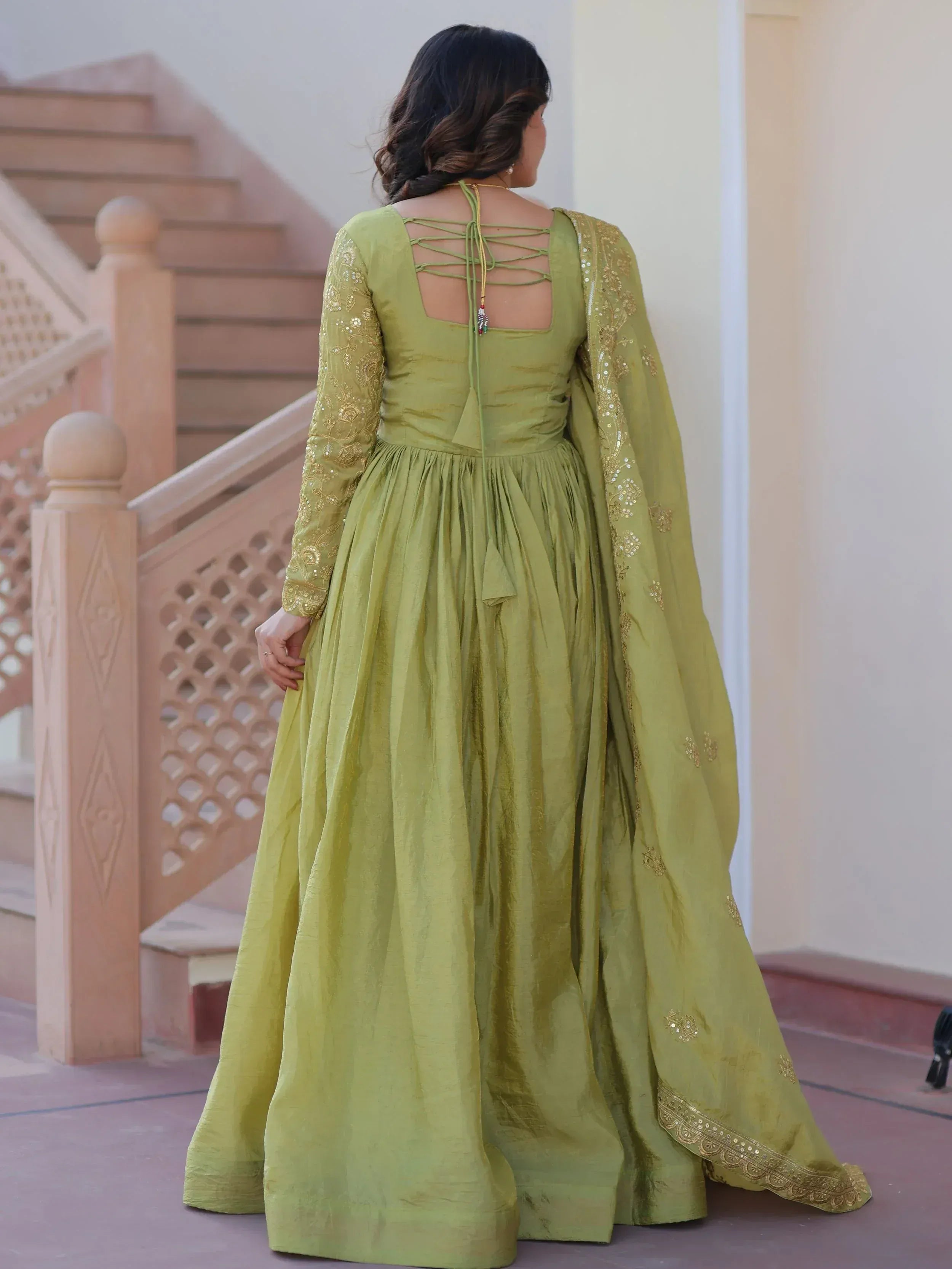 Olive green ethnic gown with gold embroidery and back tie detail, perfect for Indian occasions