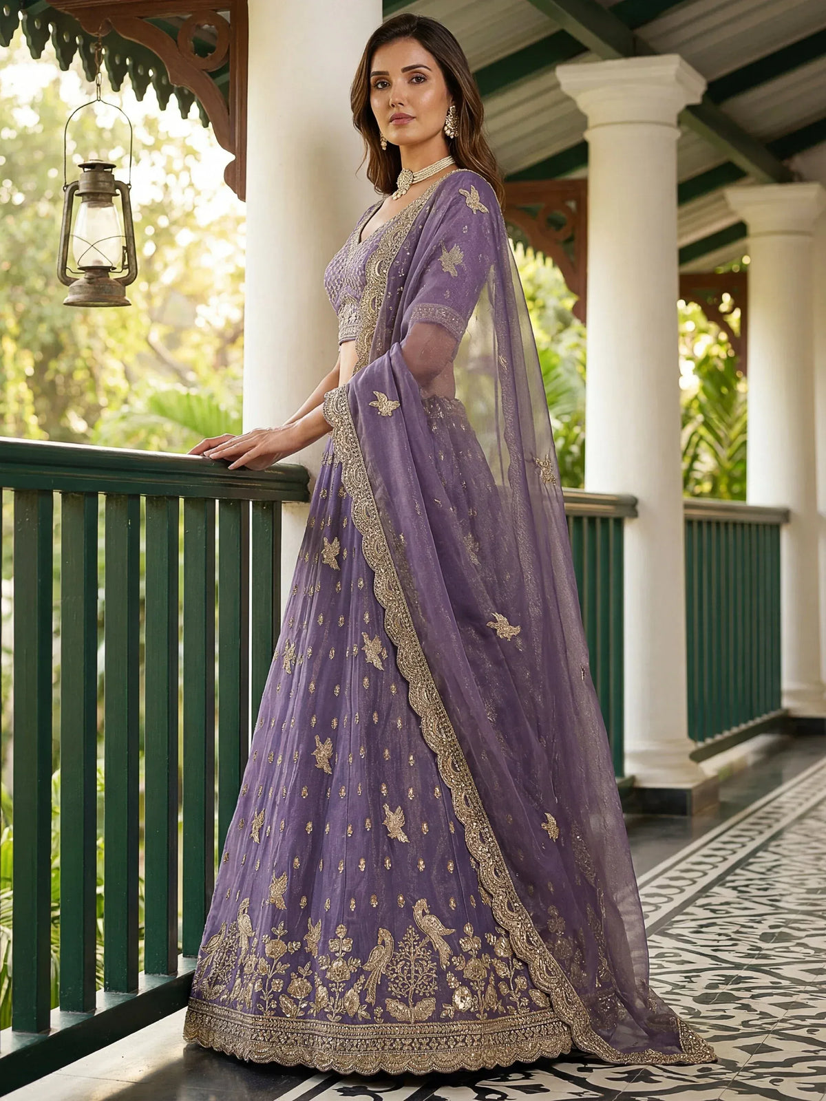 Woman wearing a purple designer lehenga choli with gold embroidery and a matching dupatta