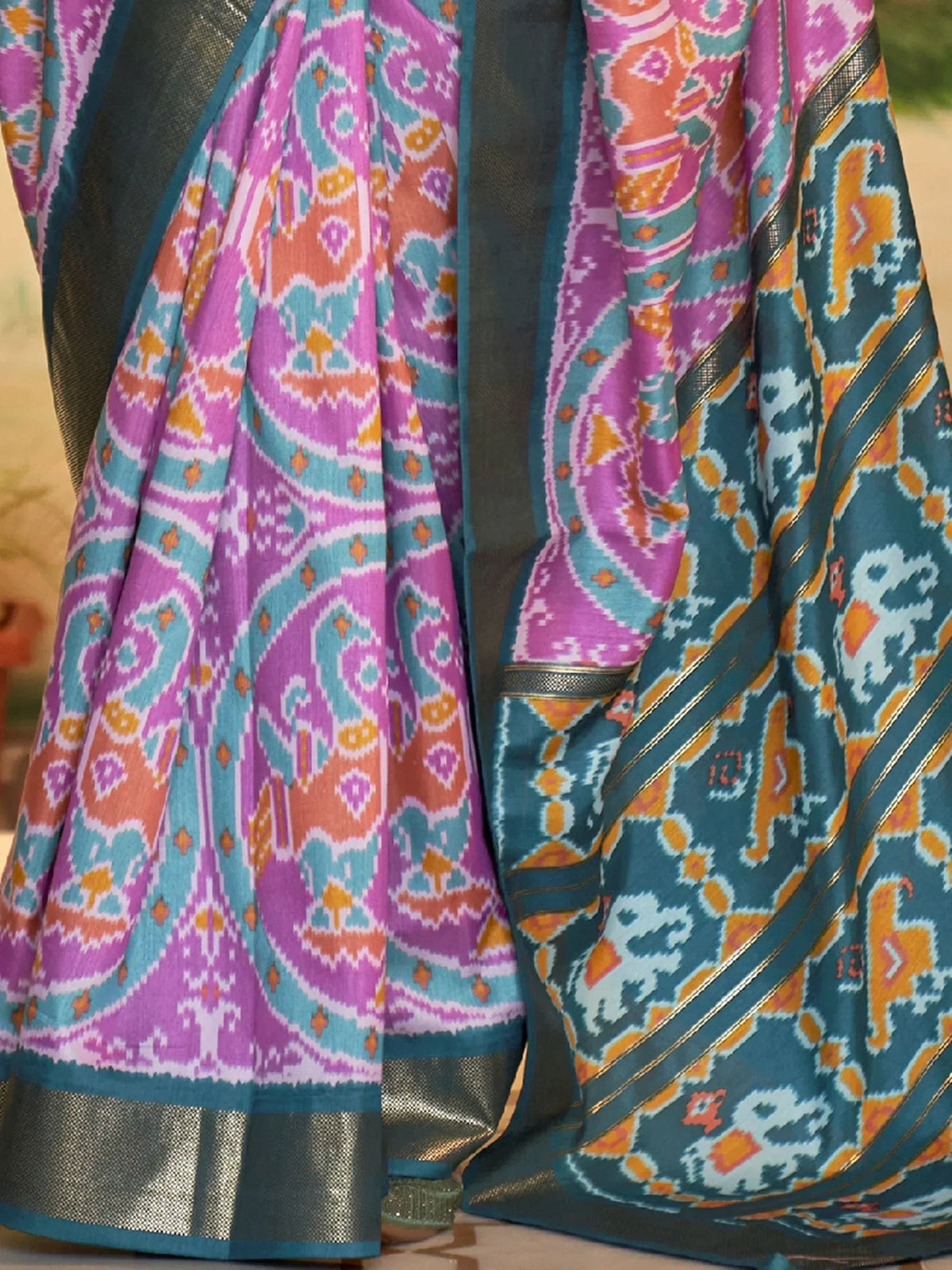Vibrant Ikat saree with pink, teal, and orange patterns, perfect for ethnic wear.