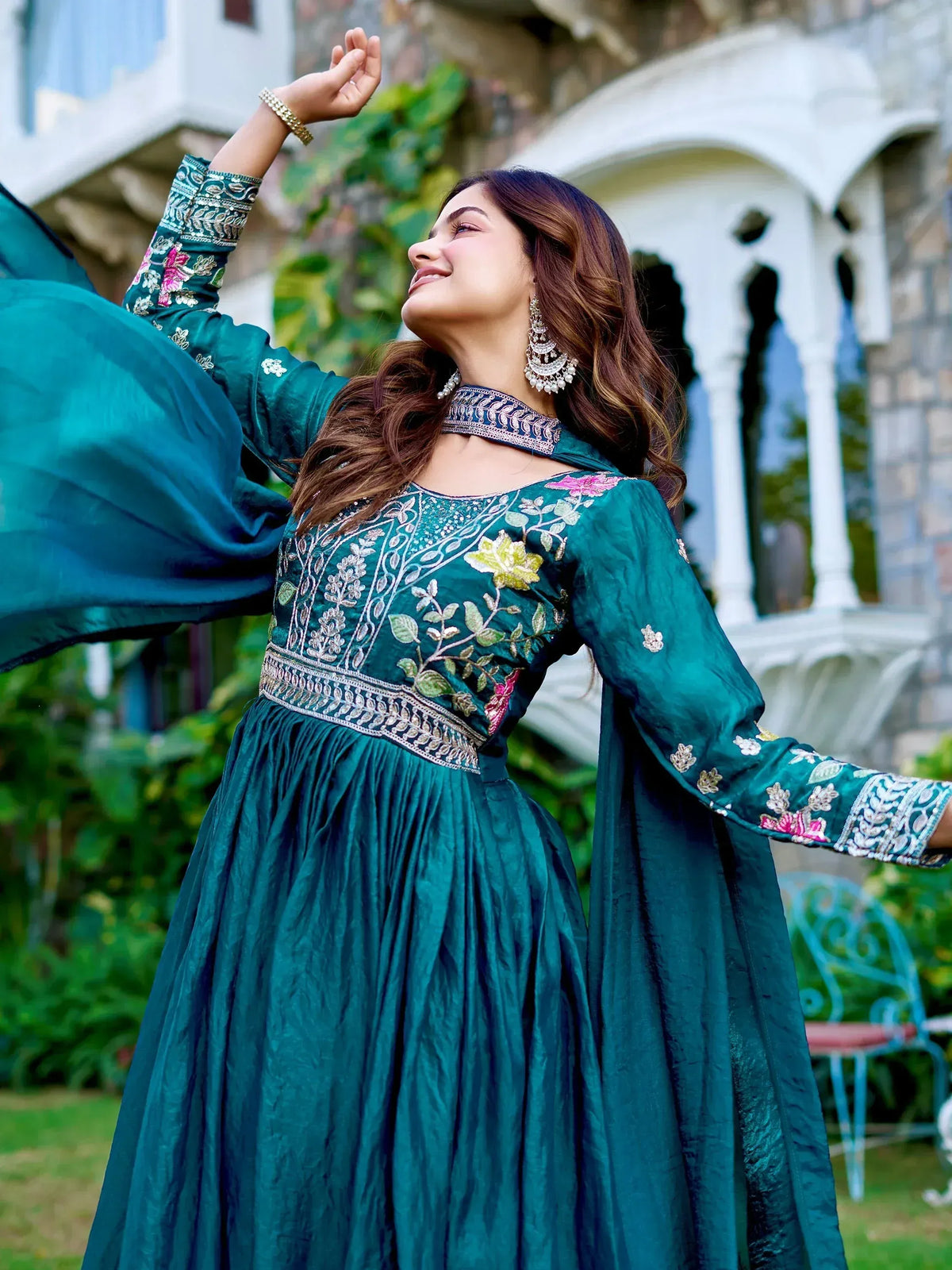 Woman in teal embroidered ethnic gown with floral details, perfect for Indian occasions