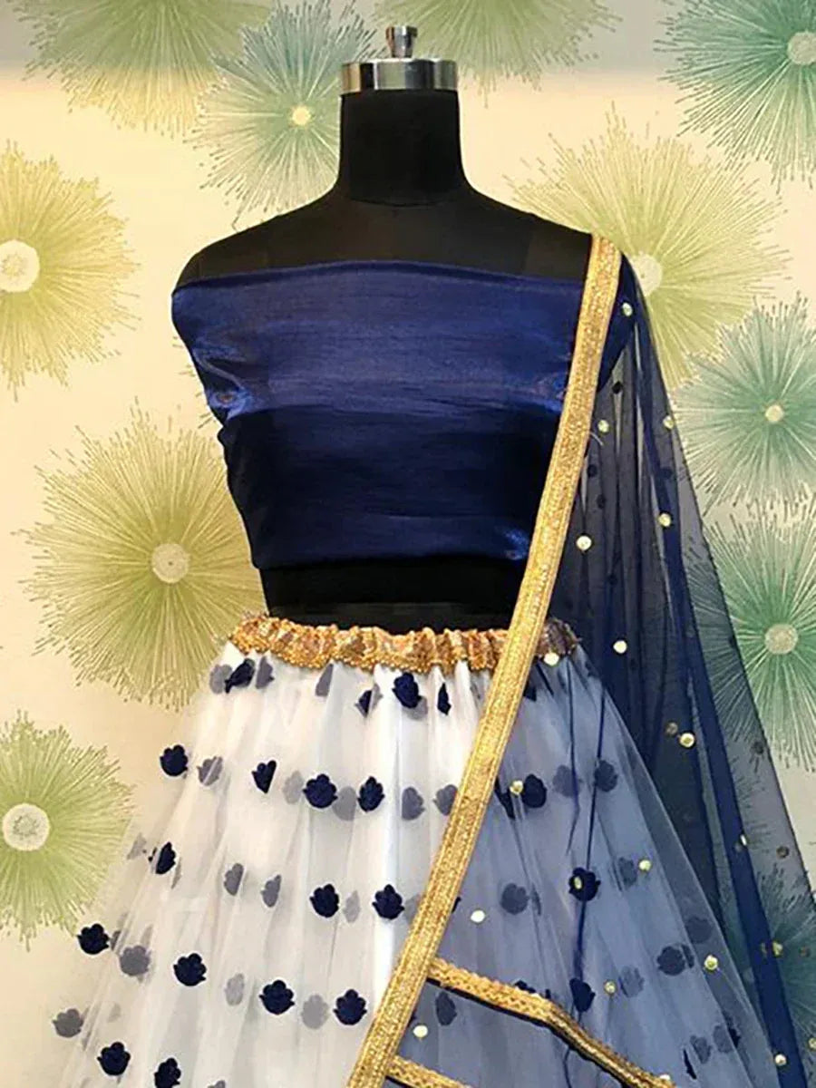 Navy blue off-shoulder lehenga choli with white net skirt, gold trim, and floral embroidery, perfect for Indian ethnic wear.