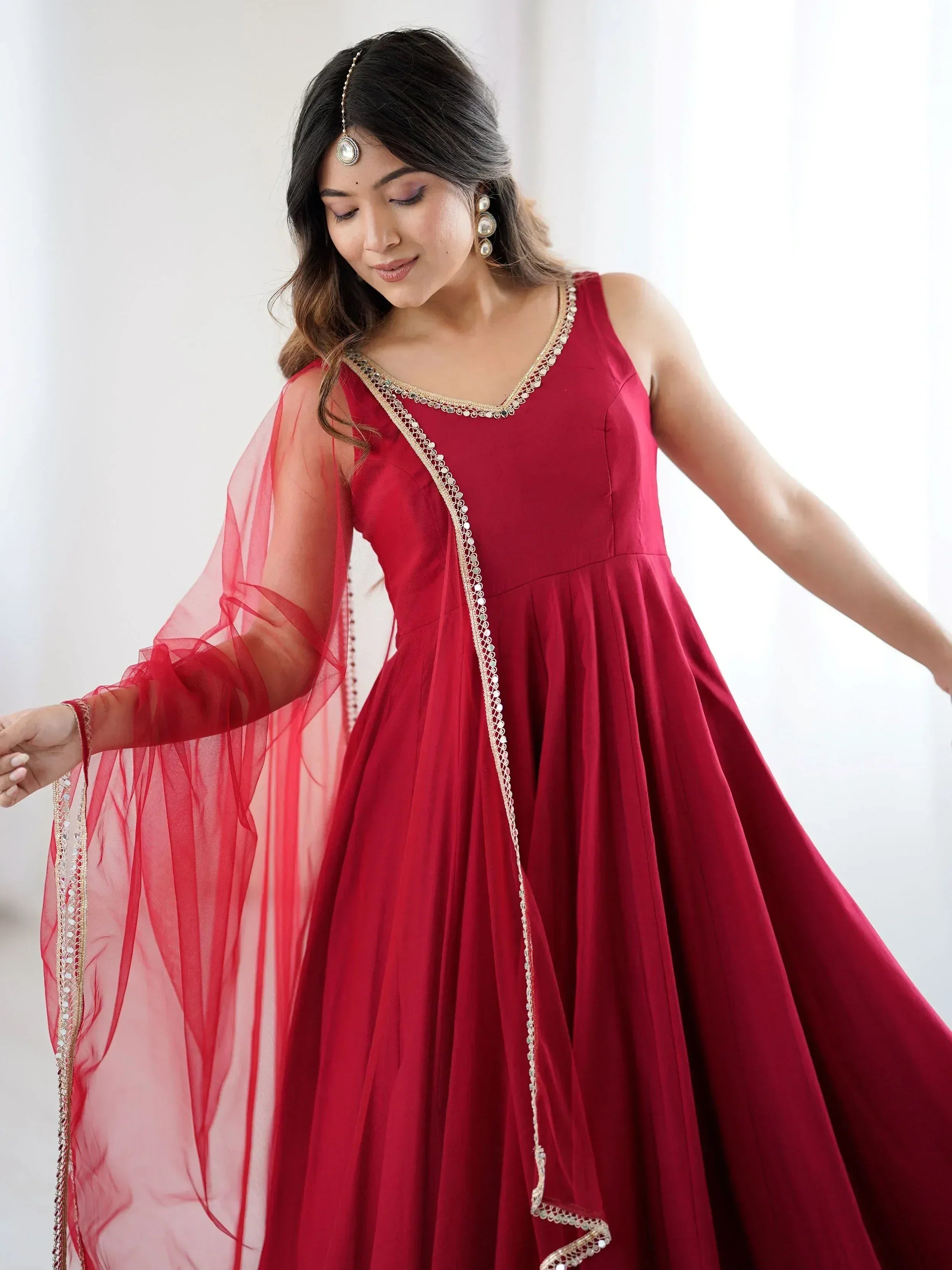 Red ethnic gown with gold embroidery and sheer dupatta, perfect for Indian weddings and festive occasions