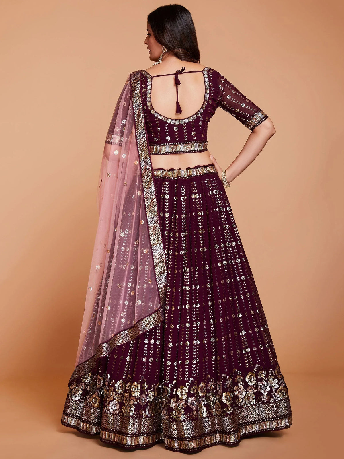 Elegant maroon lehenga choli with gold embroidery and sheer dupatta, perfect for Indian ethnic wear occasions.