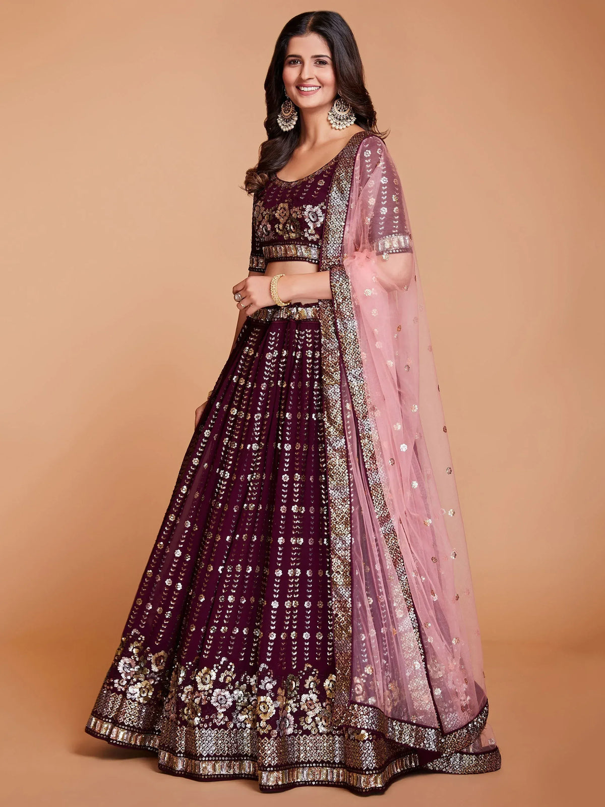 Elegant maroon lehenga choli with gold embroidery and pink dupatta, perfect for Indian weddings and festive occasions.