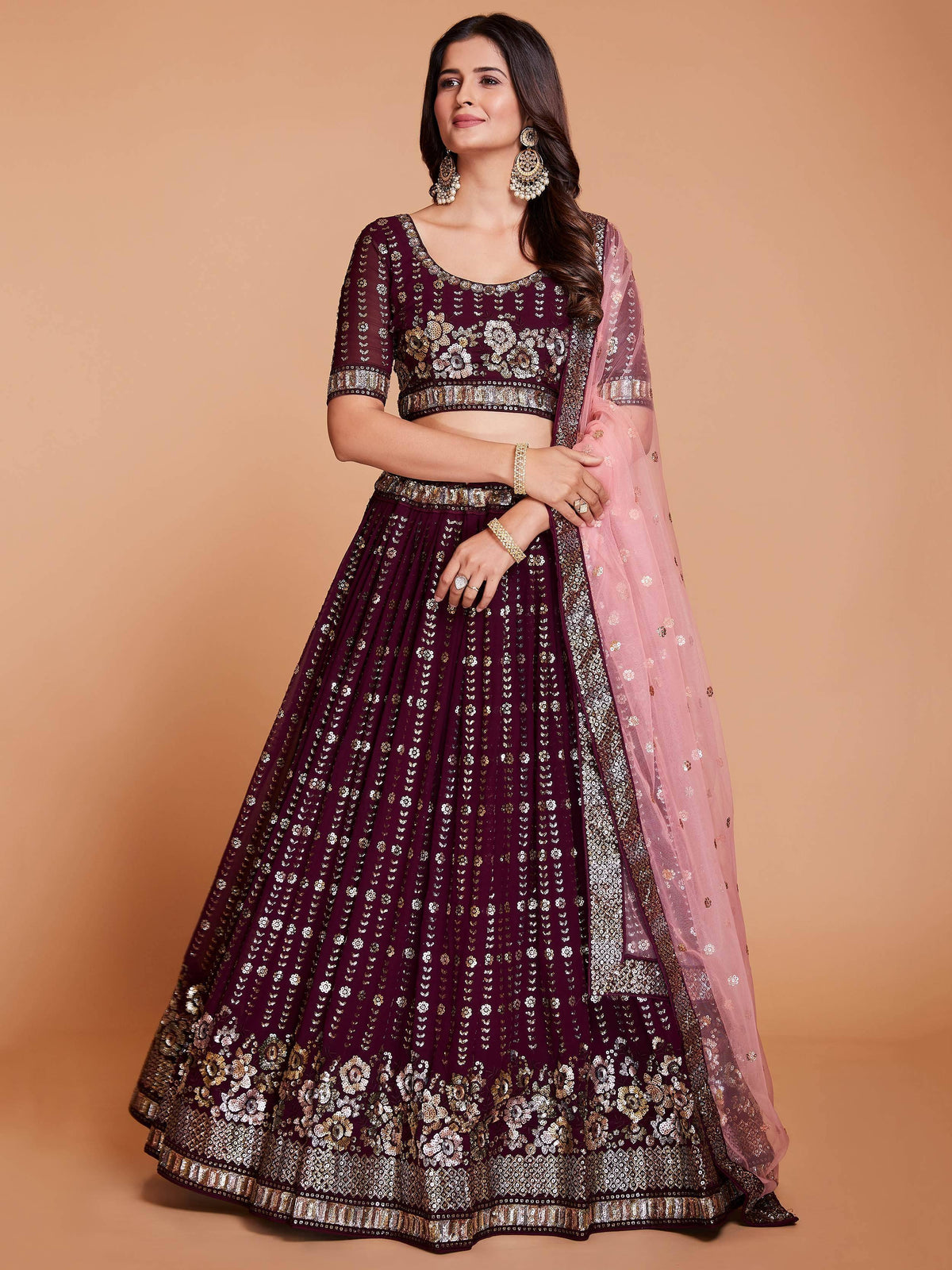 Elegant maroon lehenga choli with gold floral embroidery and pink dupatta, perfect for Indian weddings and festive occasions.