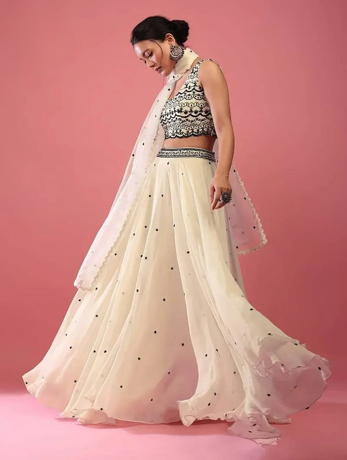 Elegant white lehenga choli with black embroidery and polka dots, perfect for Indian ethnic wear occasions.