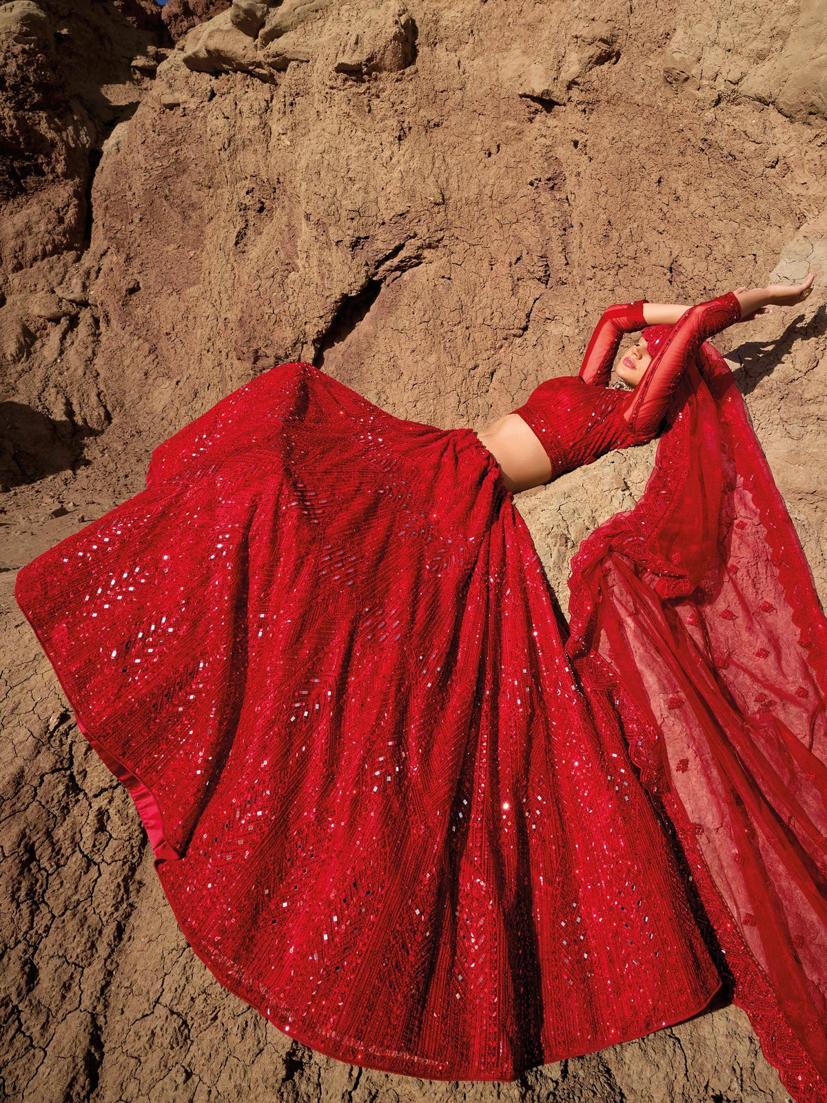 Red sequin lehenga choli with sheer dupatta, styled against desert backdrop for ethnic wear