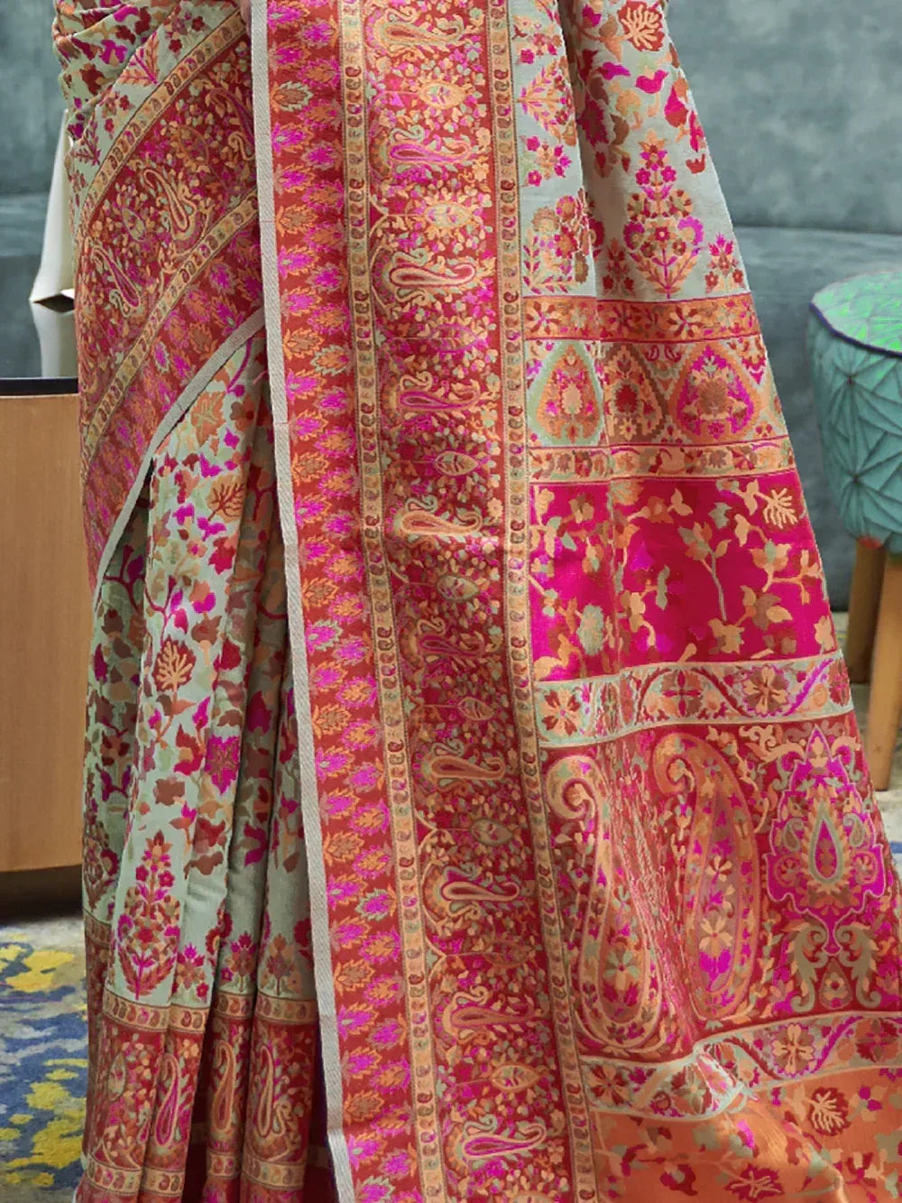 Vibrant pink and orange designer saree with intricate paisley and floral embroidery, perfect for ethnic occasions.