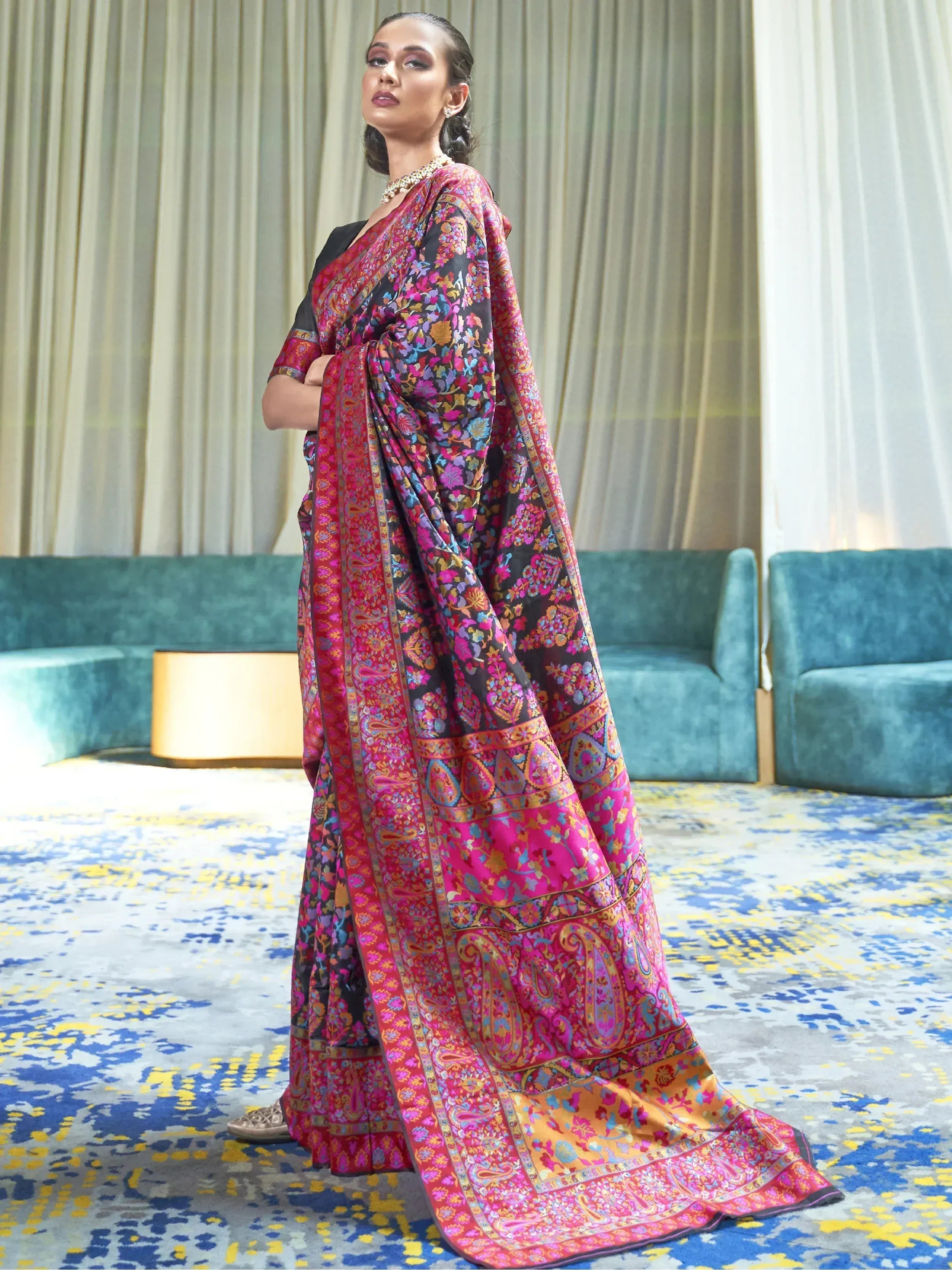 Woman in vibrant floral and paisley printed saree with black blouse, perfect for ethnic occasions