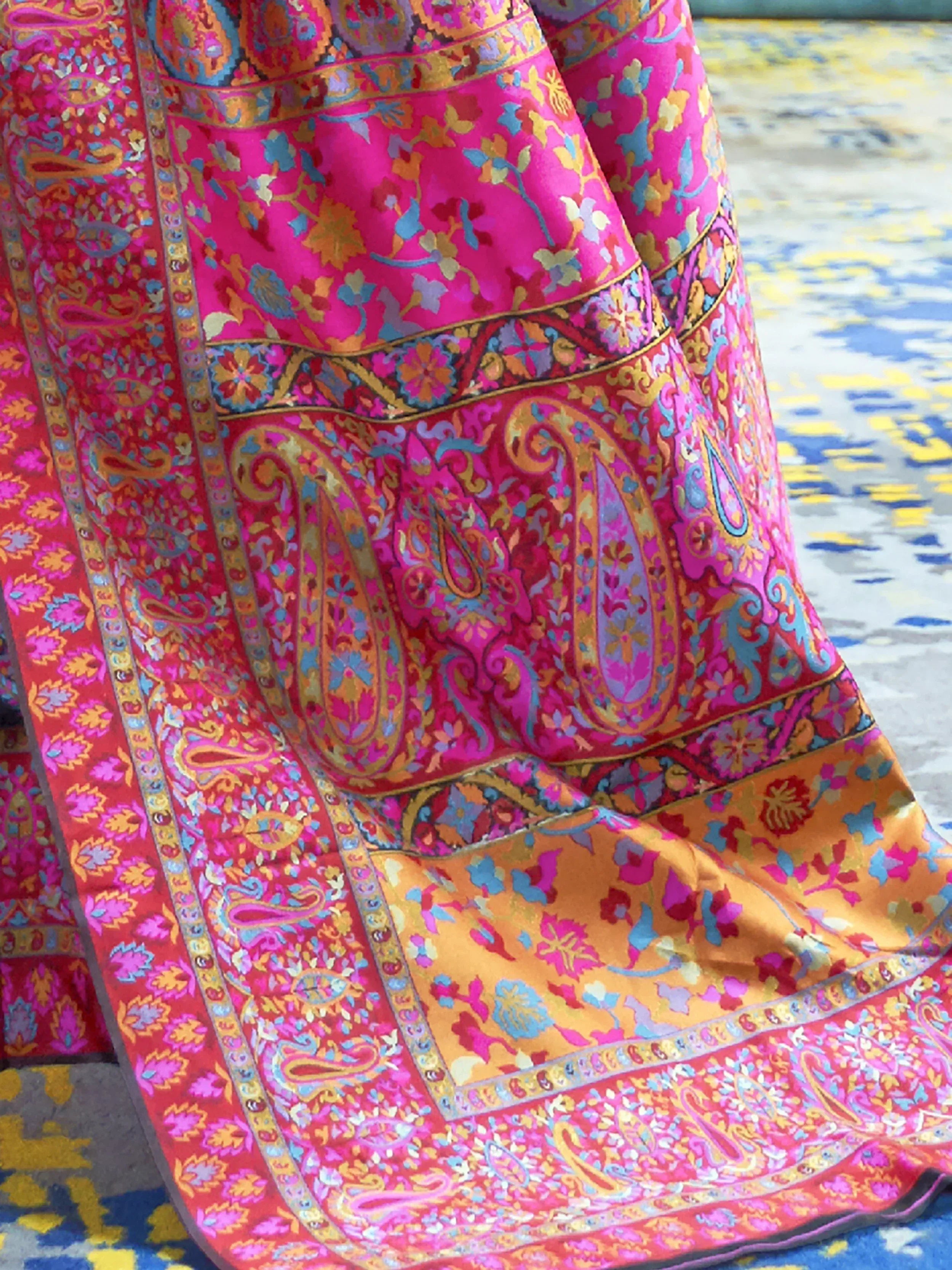 Vibrant pink and gold Indian ethnic saree with intricate paisley and floral prints, perfect for festive occasions.
