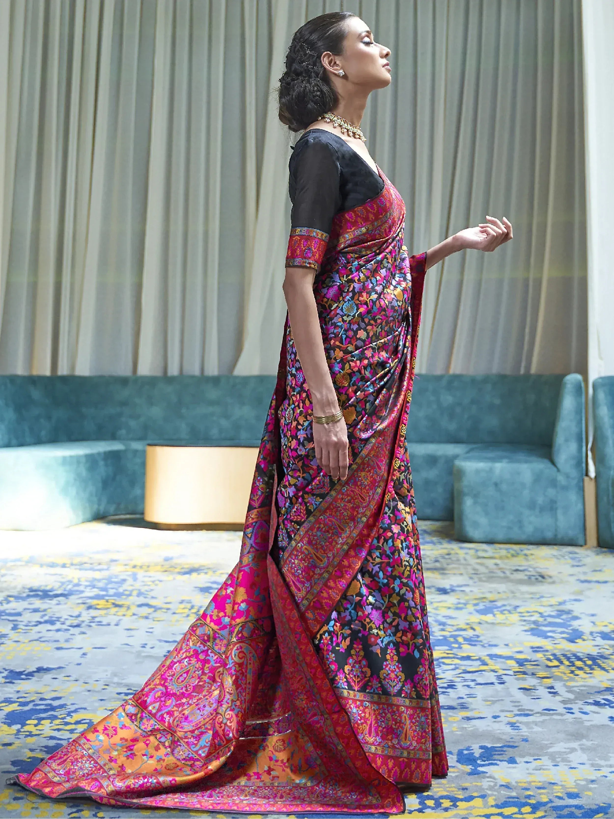 Woman in vibrant floral and paisley saree with black blouse, Indian ethnic wear