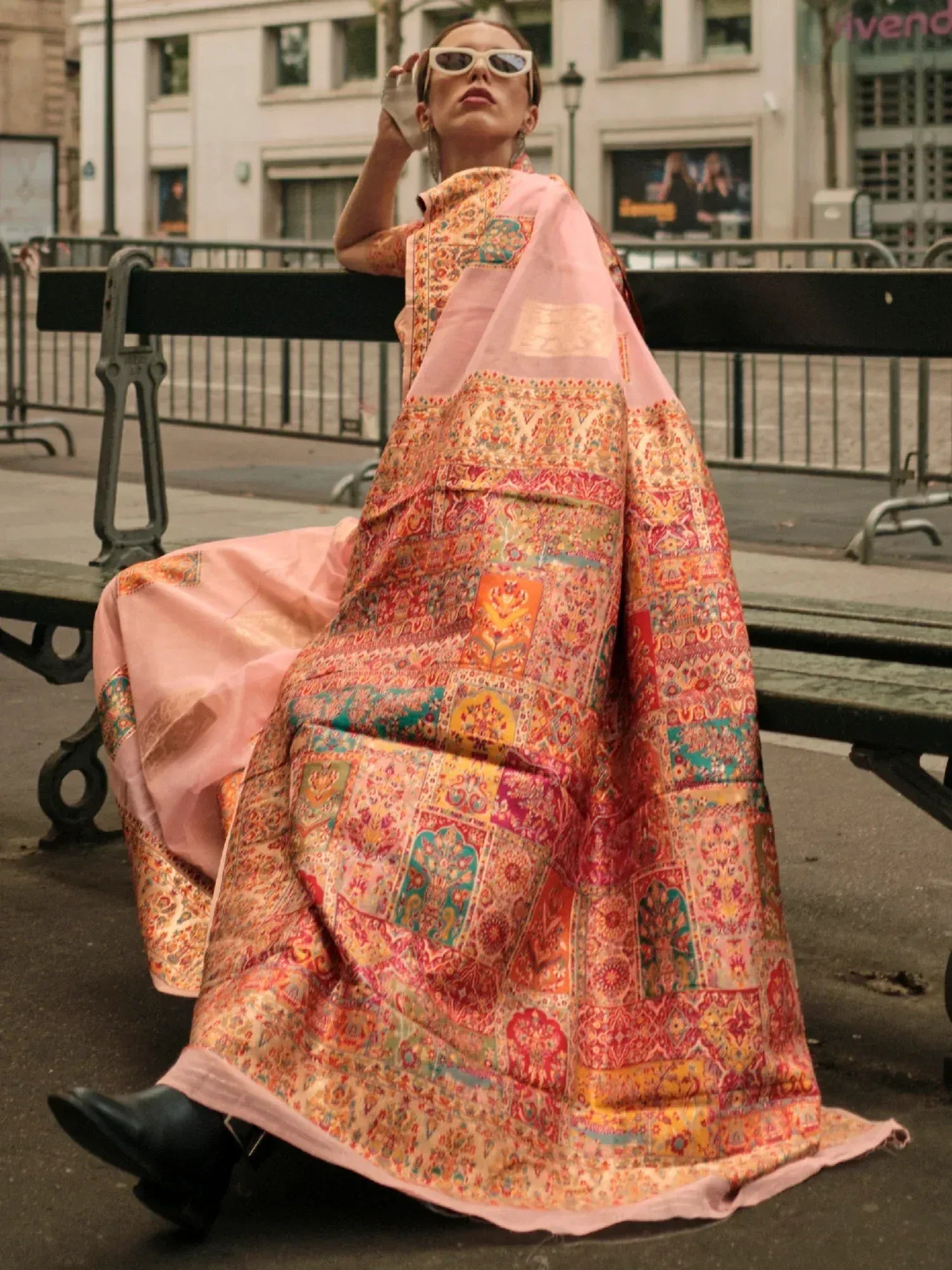 Woman in vibrant patchwork ethnic gown with pink dupatta, styled for street fashion