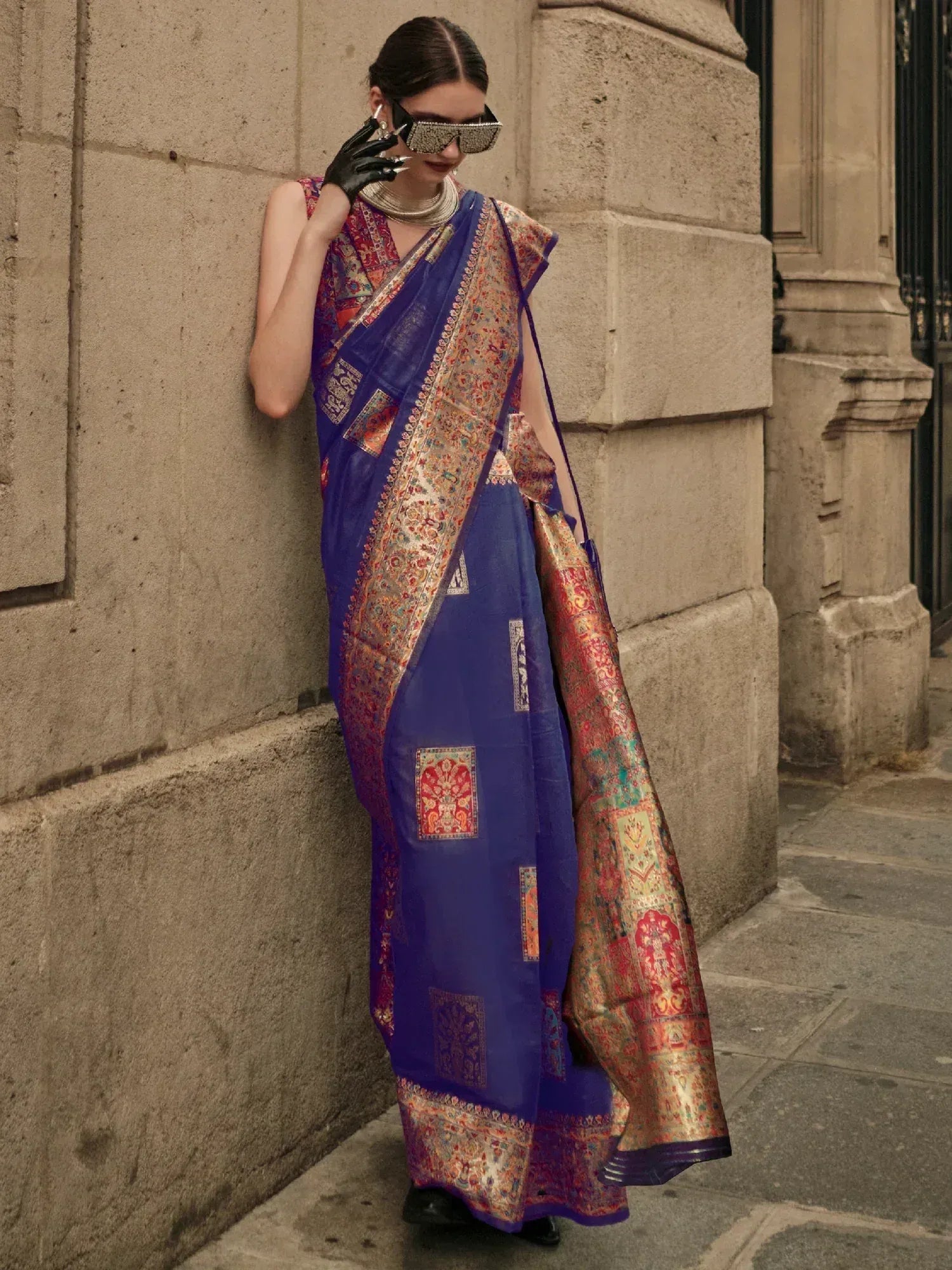 Woman in royal blue printed saree with gold border, styled for ethnic occasions
