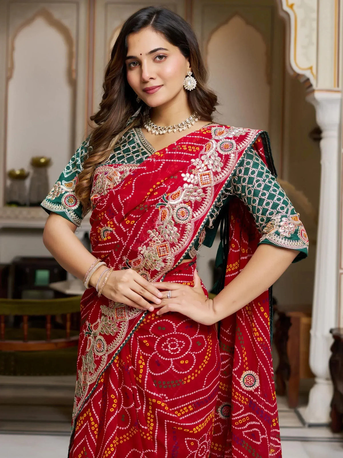 Woman in red and green embroidered saree with traditional Indian jewelry, perfect for ethnic occasions.