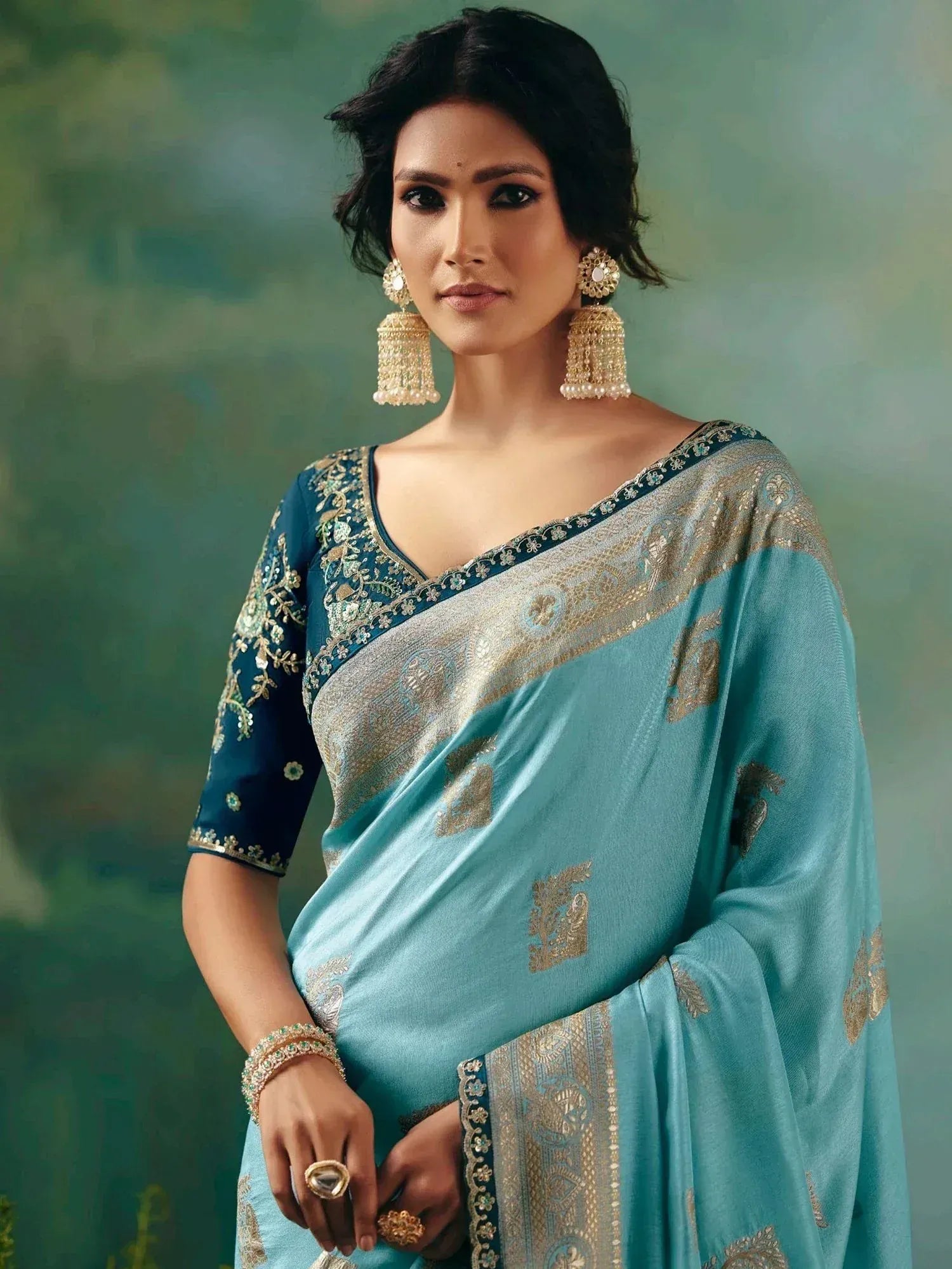 Elegant teal saree with gold embroidery, designer blouse, and jhumka earrings for Indian ethnic wear