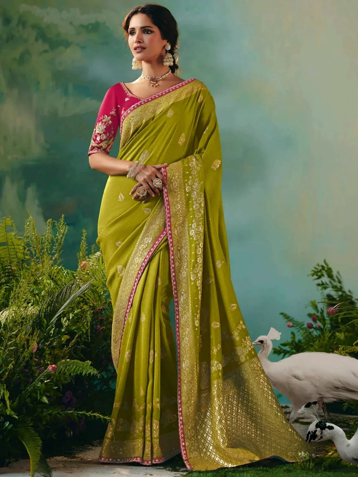 Elegant green saree with gold embroidery and pink blouse, styled with traditional jewelry for festive occasions.