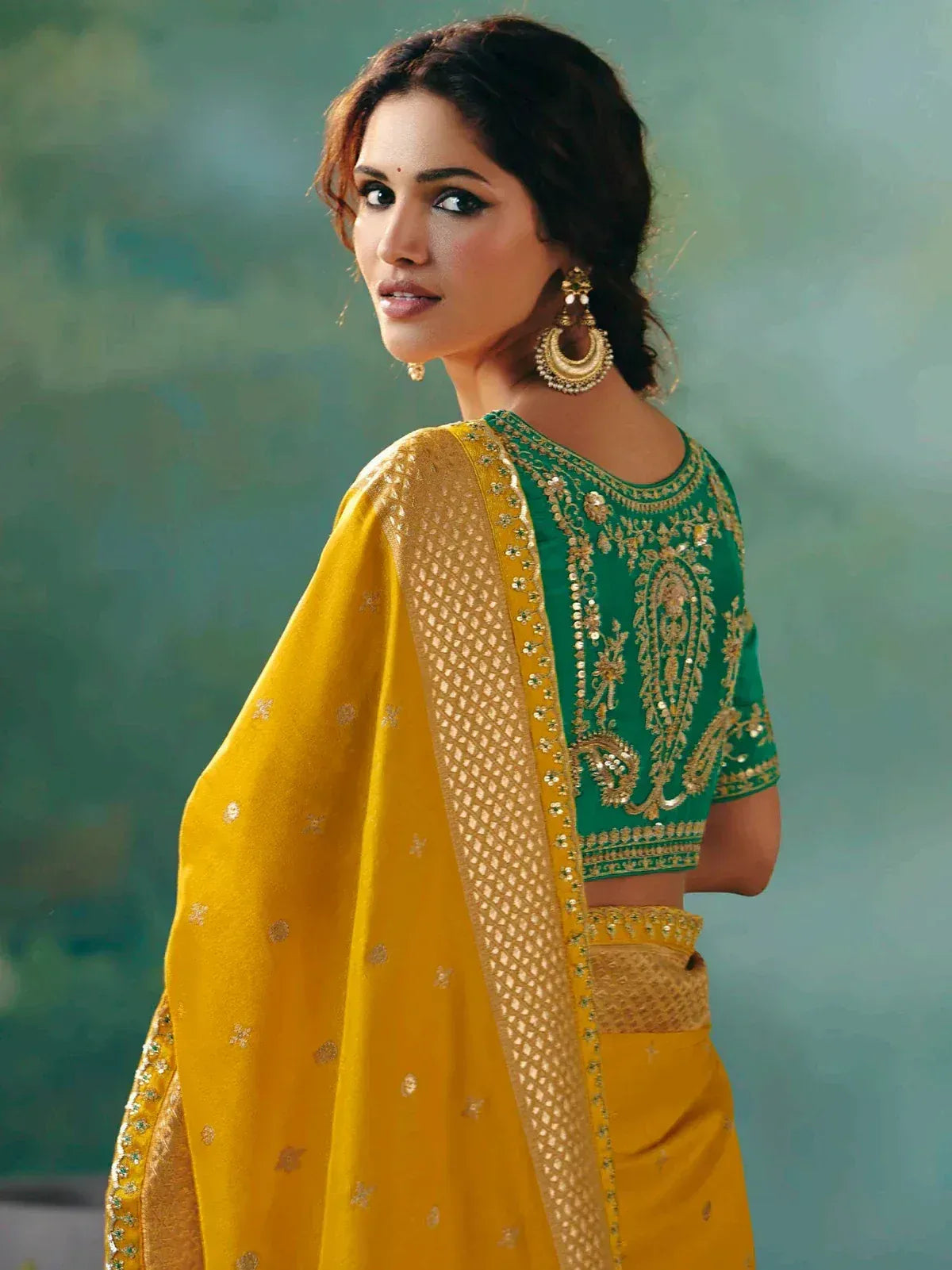 Green and yellow embroidered Indian ethnic saree with gold detailing and matching blouse
