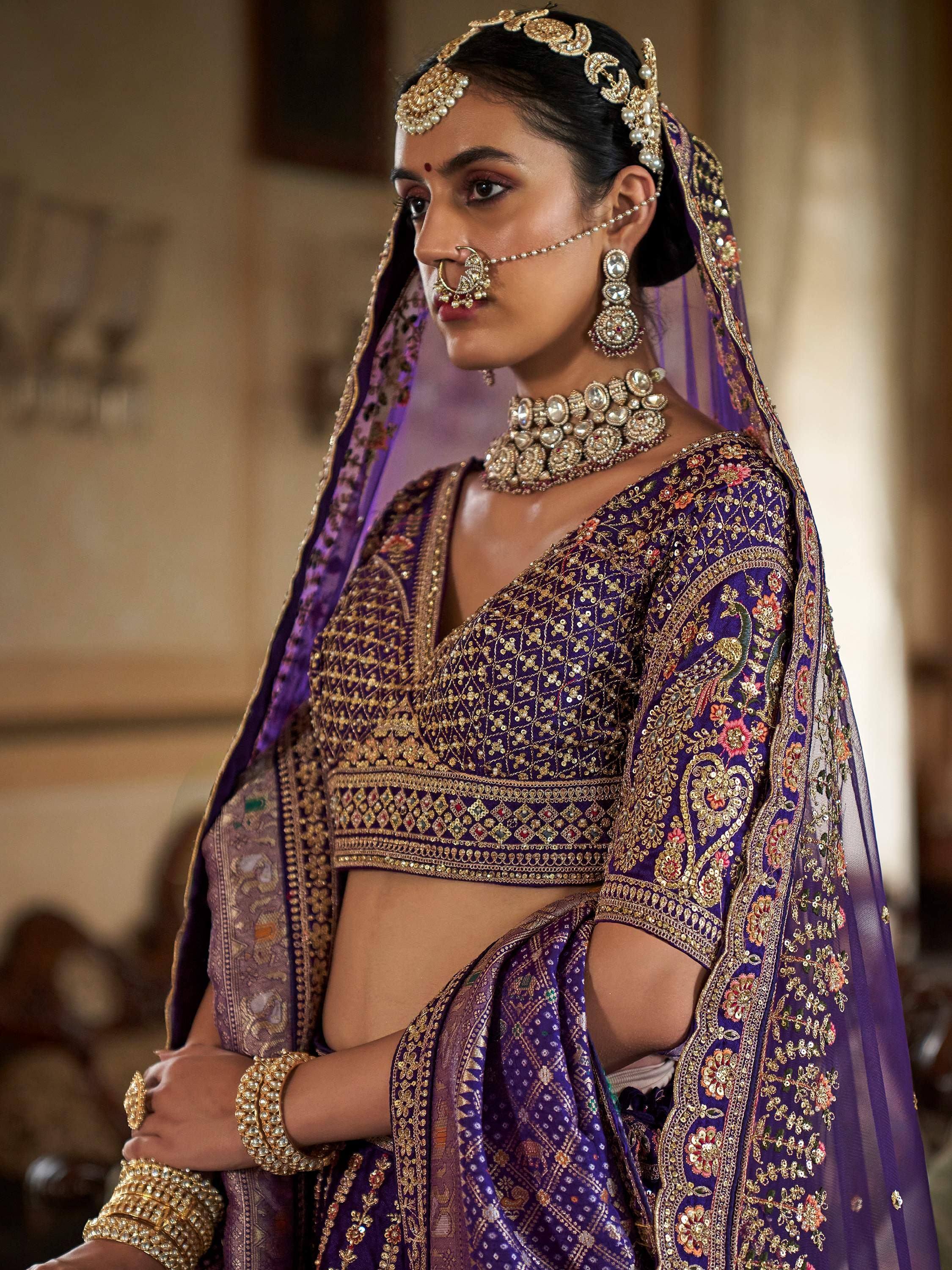 Purple embroidered lehenga choli with gold detailing, traditional Indian bridal wear, heavy jewelry set