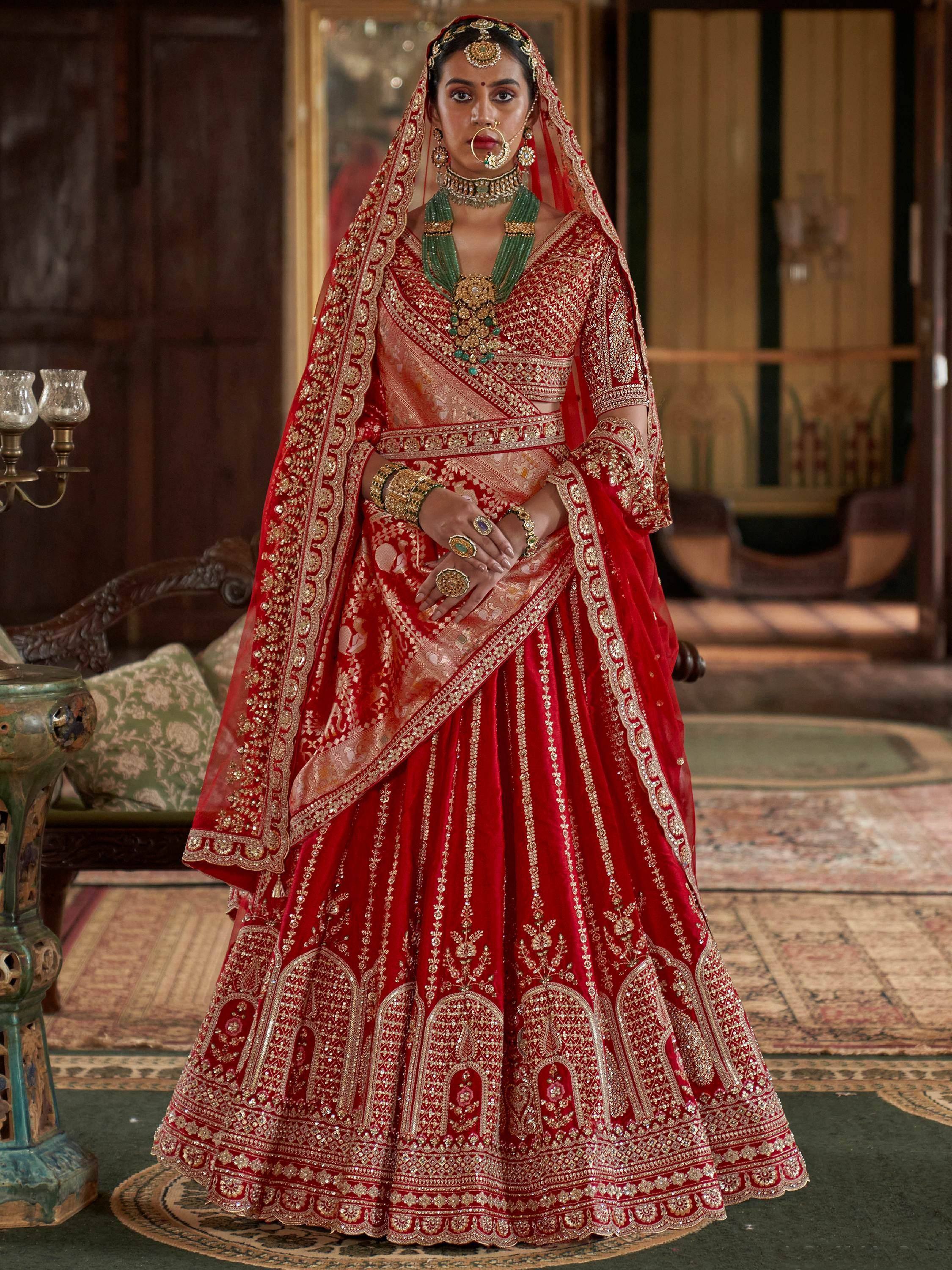 Red embroidered lehenga choli with gold detailing, perfect for Indian weddings and festive occasions.