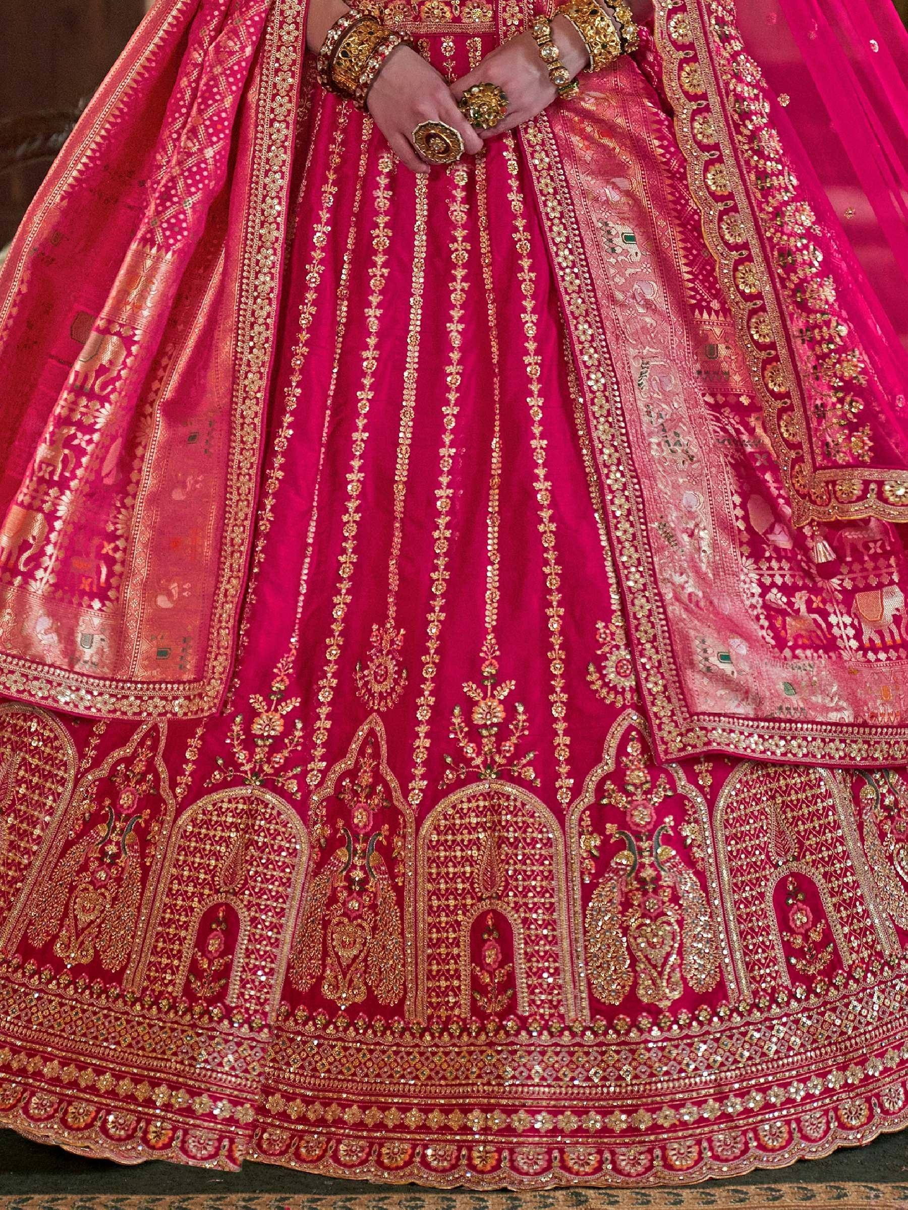 Fuchsia pink designer lehenga with heavy gold embroidery, sequins, and traditional motifs for Indian weddings