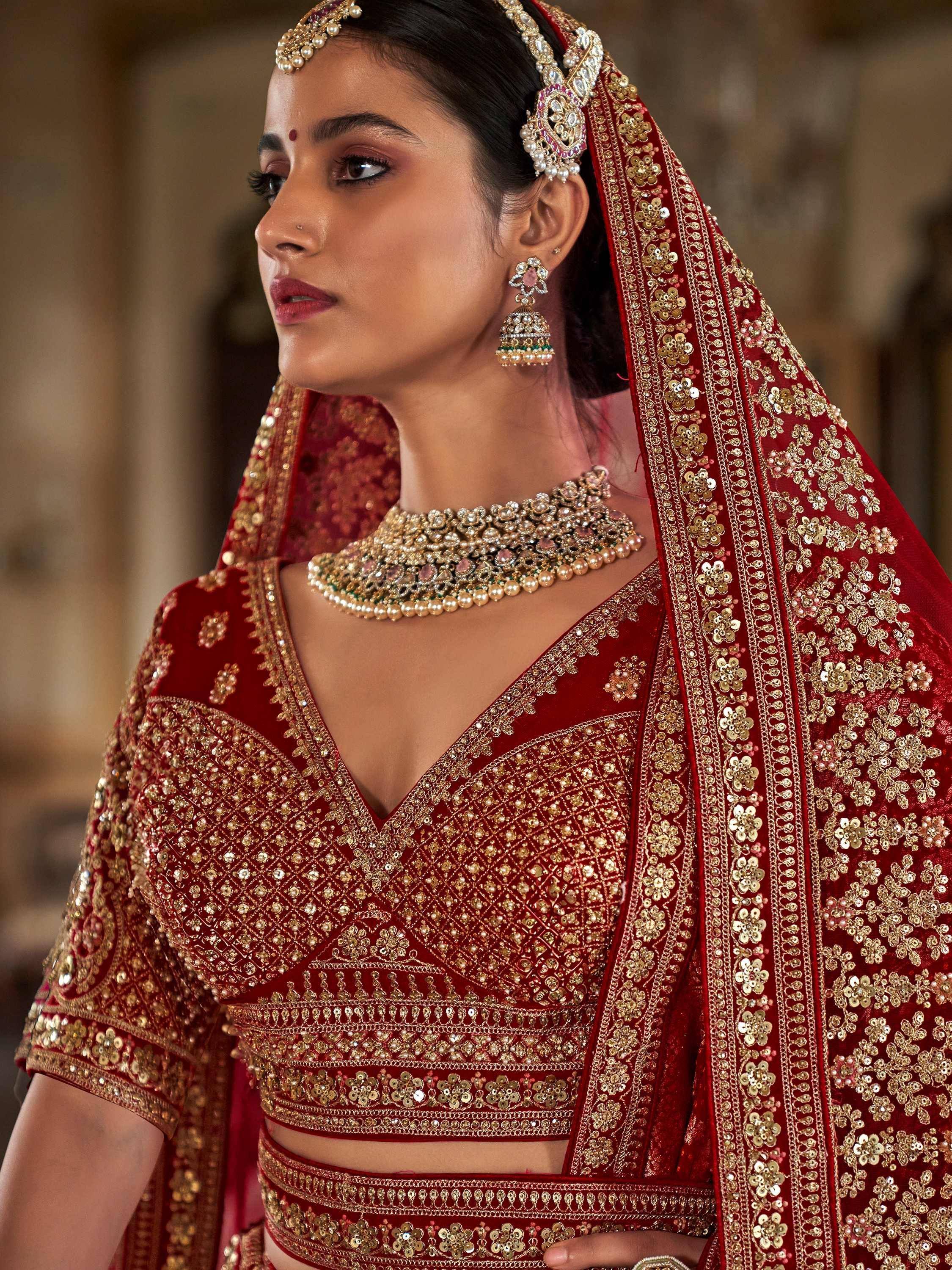 Red embroidered lehenga choli with gold detailing, traditional Indian bridal wear
