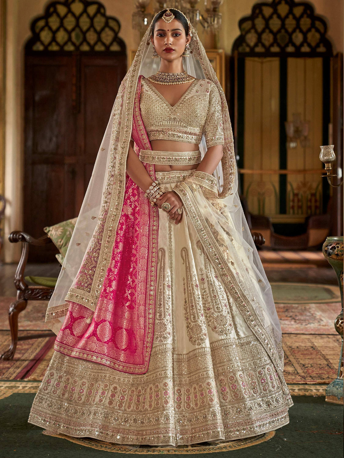 Elegant ivory and pink designer lehenga choli with heavy embroidery and dupatta, perfect for Indian weddings.