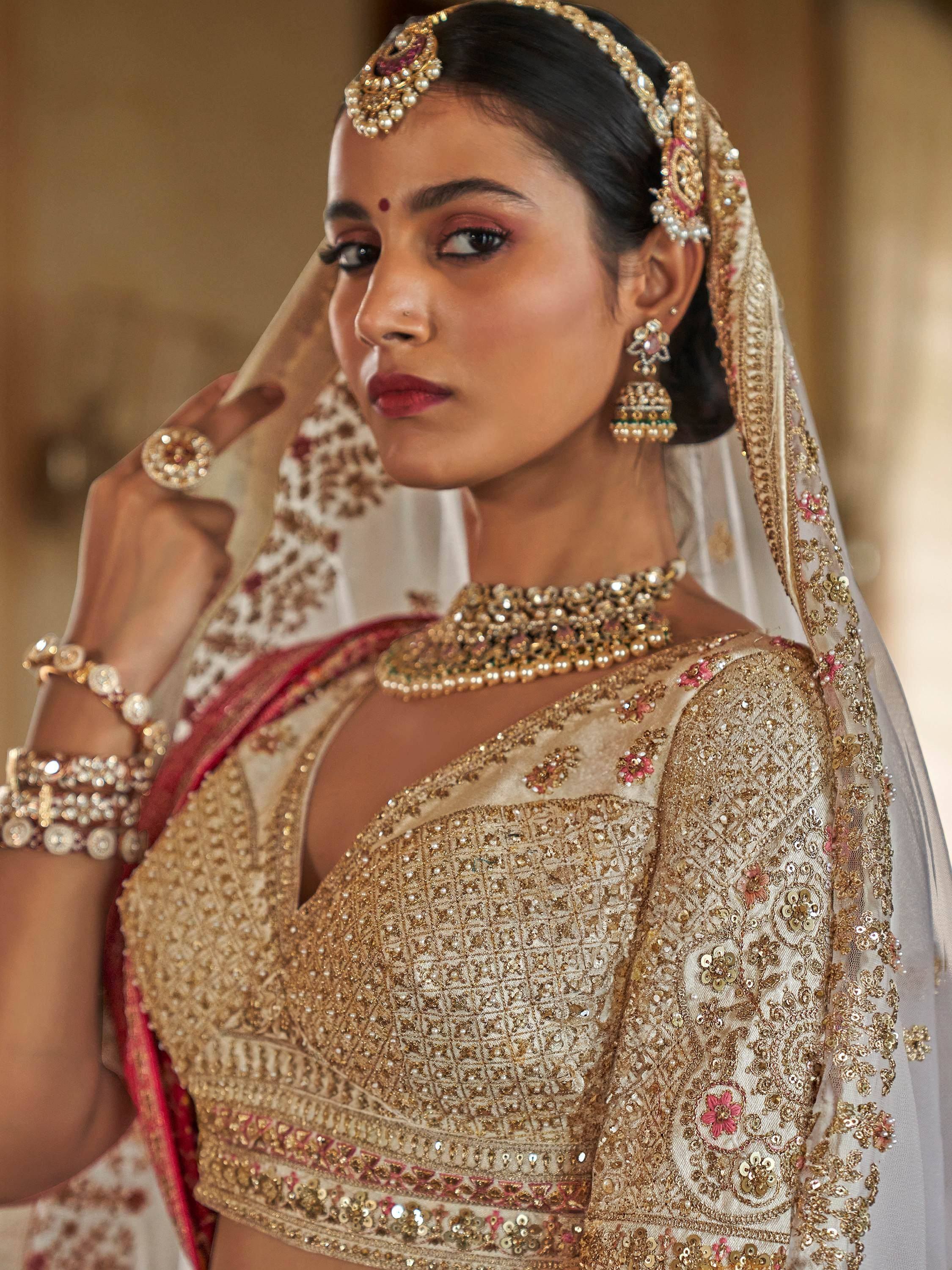 Elegant Indian bride in gold embroidered lehenga choli with matching jewelry and dupatta