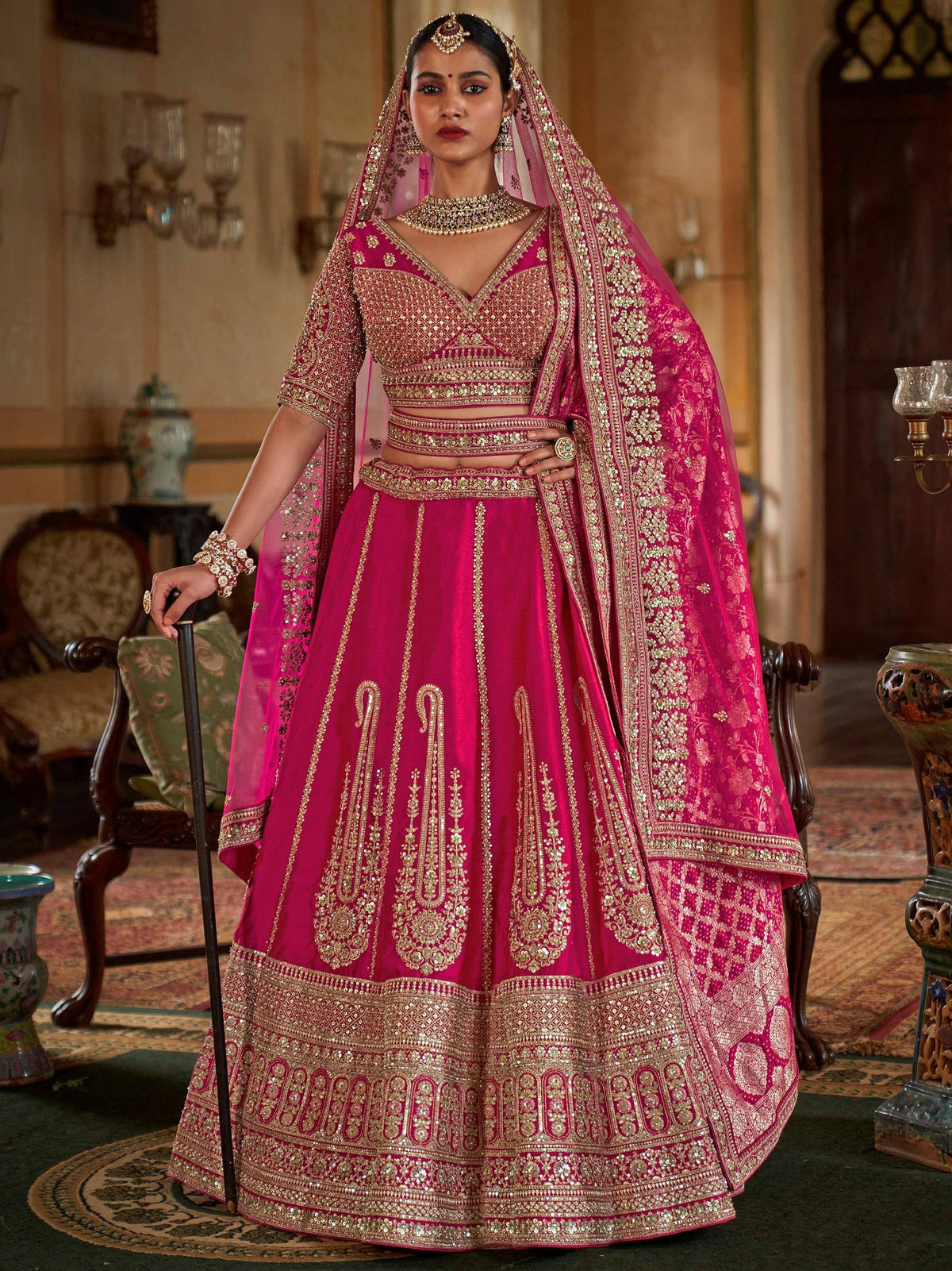 Fuchsia pink designer lehenga choli with gold embroidery, perfect for Indian weddings and ethnic events.