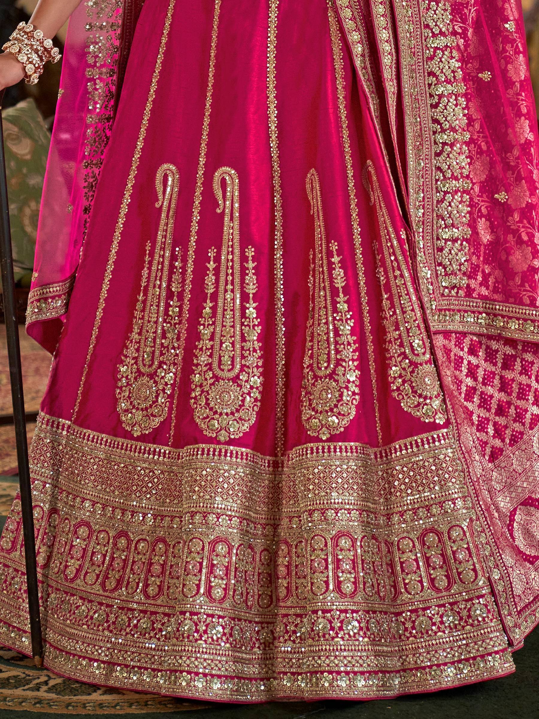 Fuchsia pink lehenga with intricate gold embroidery and sequin work, perfect for Indian weddings and festive occasions.