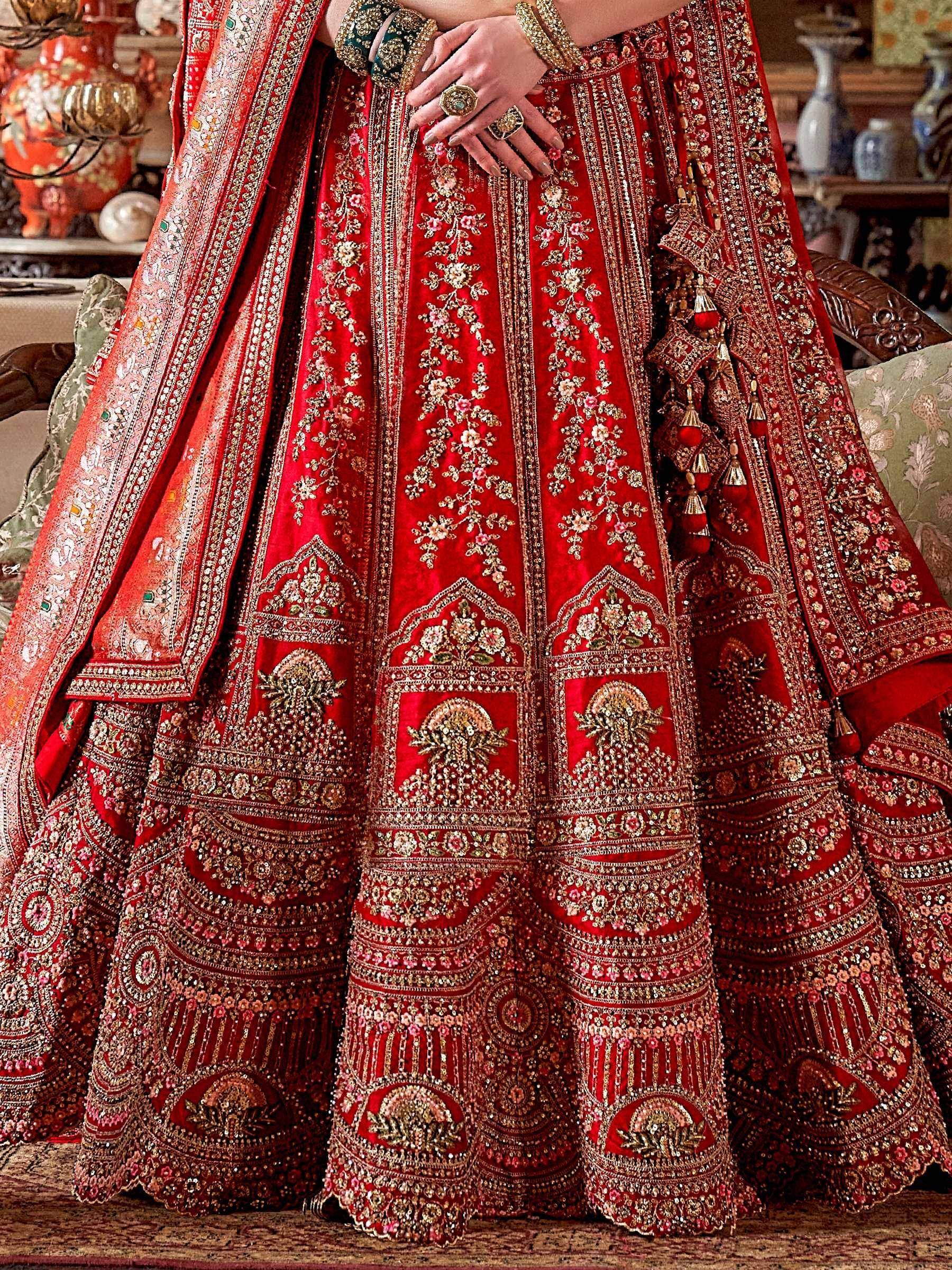 Red embroidered lehenga choli with gold floral motifs and heavy embellishments, perfect for Indian weddings