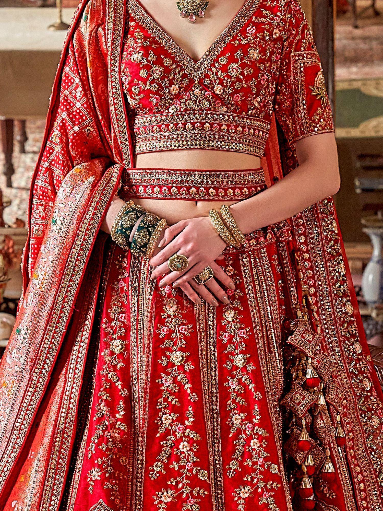 Red embroidered lehenga choli with gold floral detailing, perfect for Indian weddings and ethnic events.