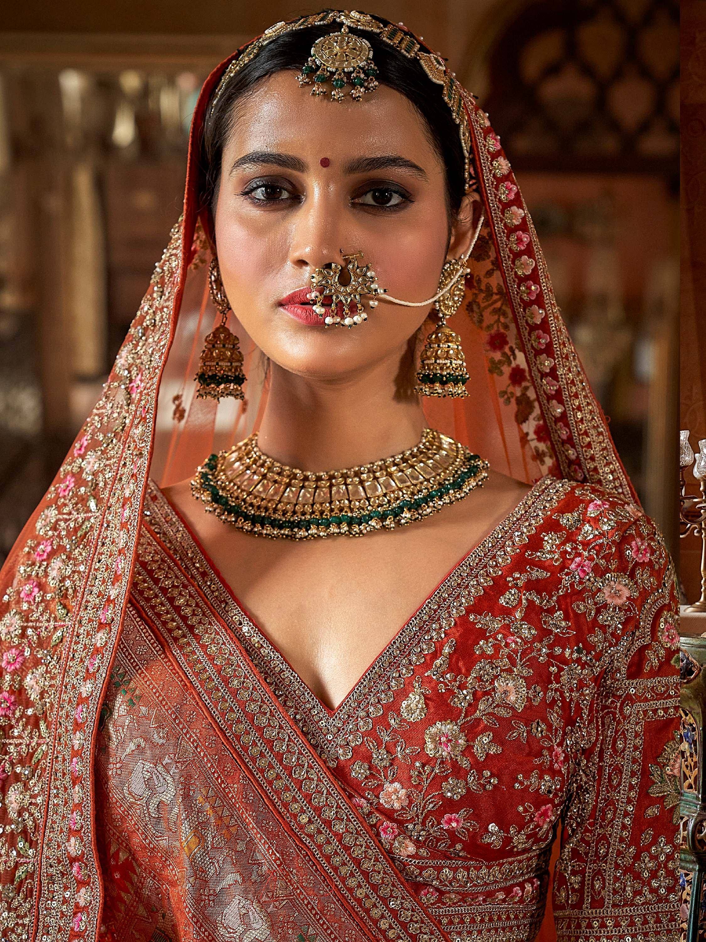 Bridal lehenga choli with intricate embroidery, maang tikka, and traditional Indian jewelry