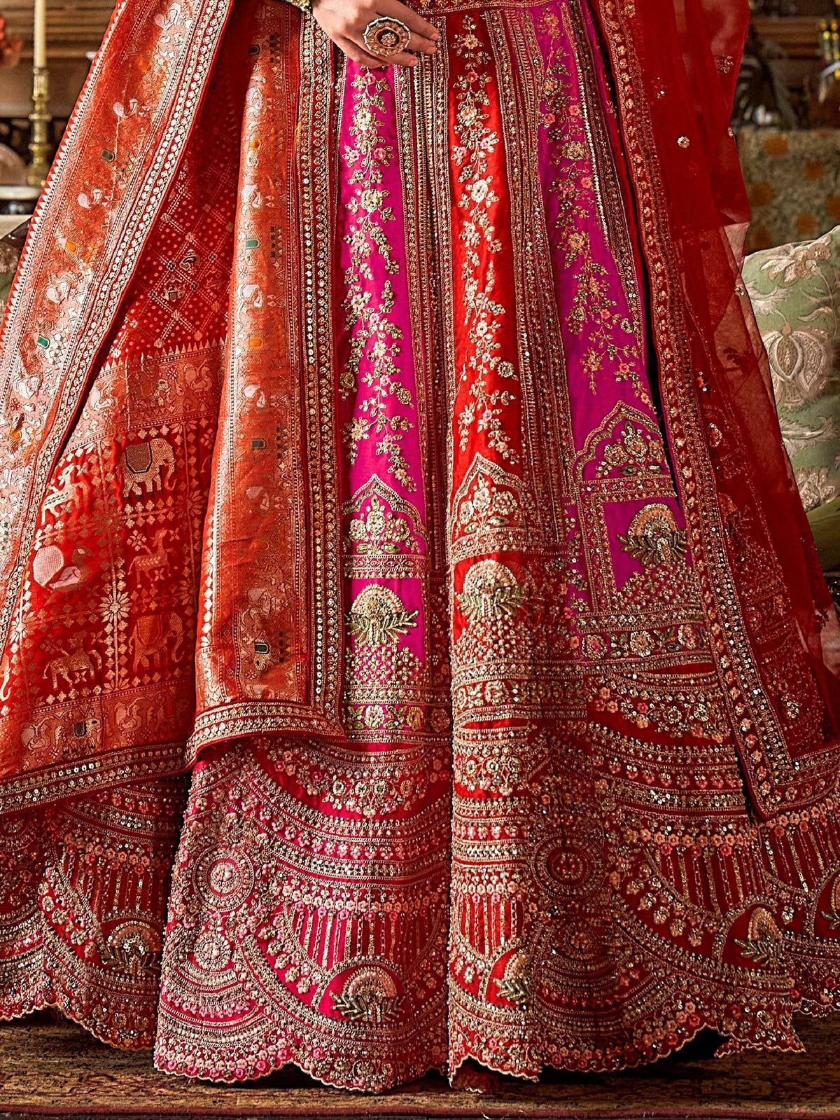 Luxury red and pink embroidered lehenga choli with intricate gold detailing and traditional Indian motifs