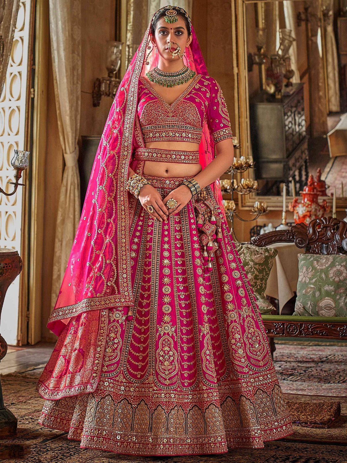 Fuchsia pink designer lehenga choli with gold embroidery, perfect for Indian weddings and ethnic events.