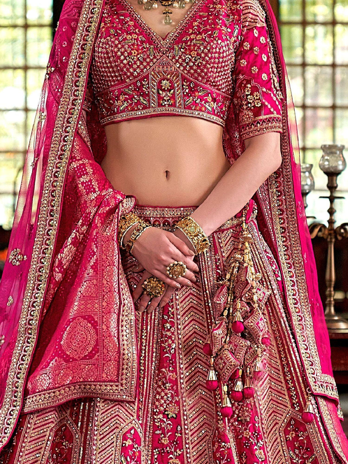 Fuchsia pink embroidered lehenga choli with gold detailing, perfect for Indian weddings and festive occasions.
