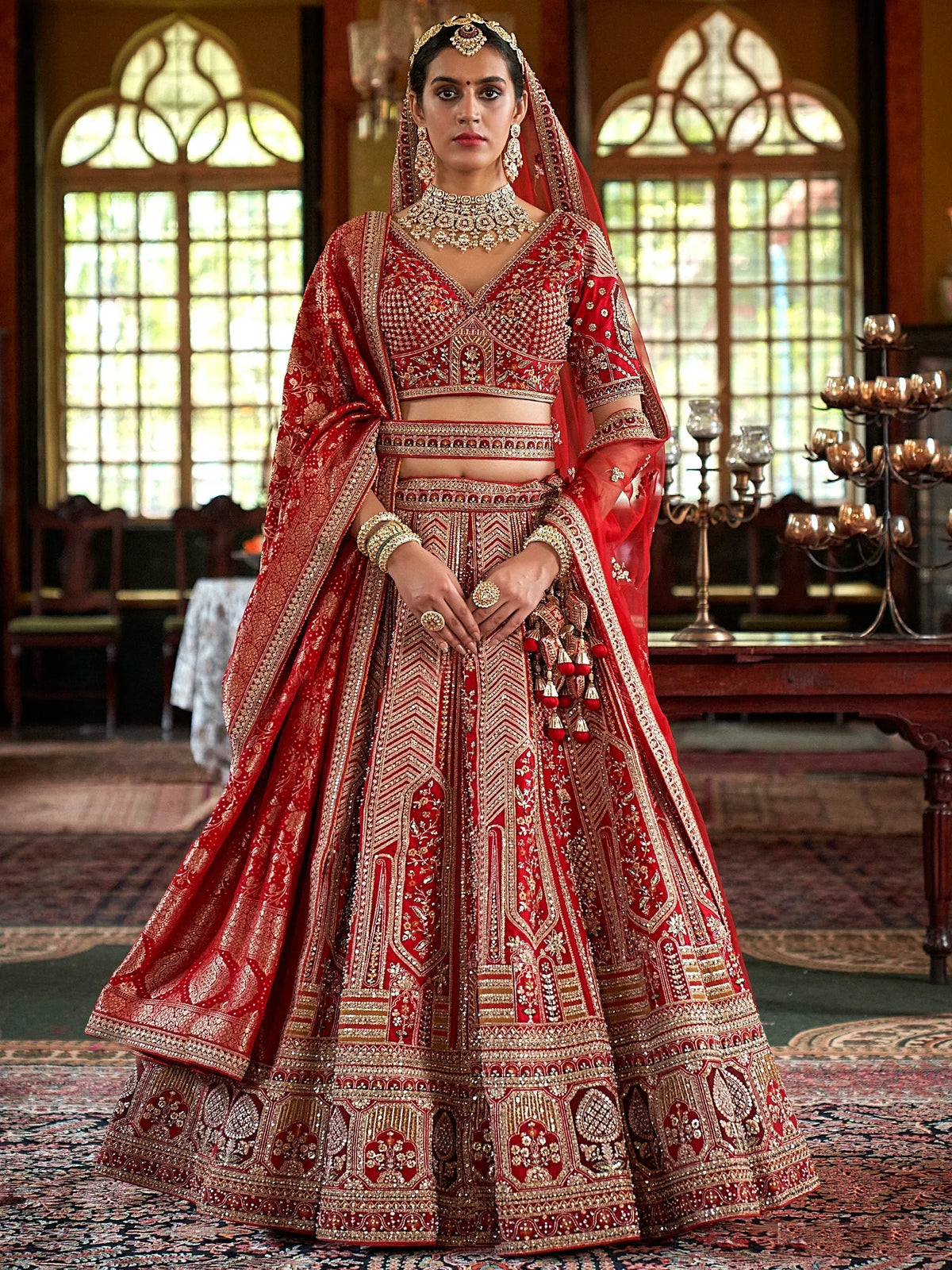 Red and gold bridal lehenga choli with heavy embroidery, perfect for Indian weddings and ethnic events.