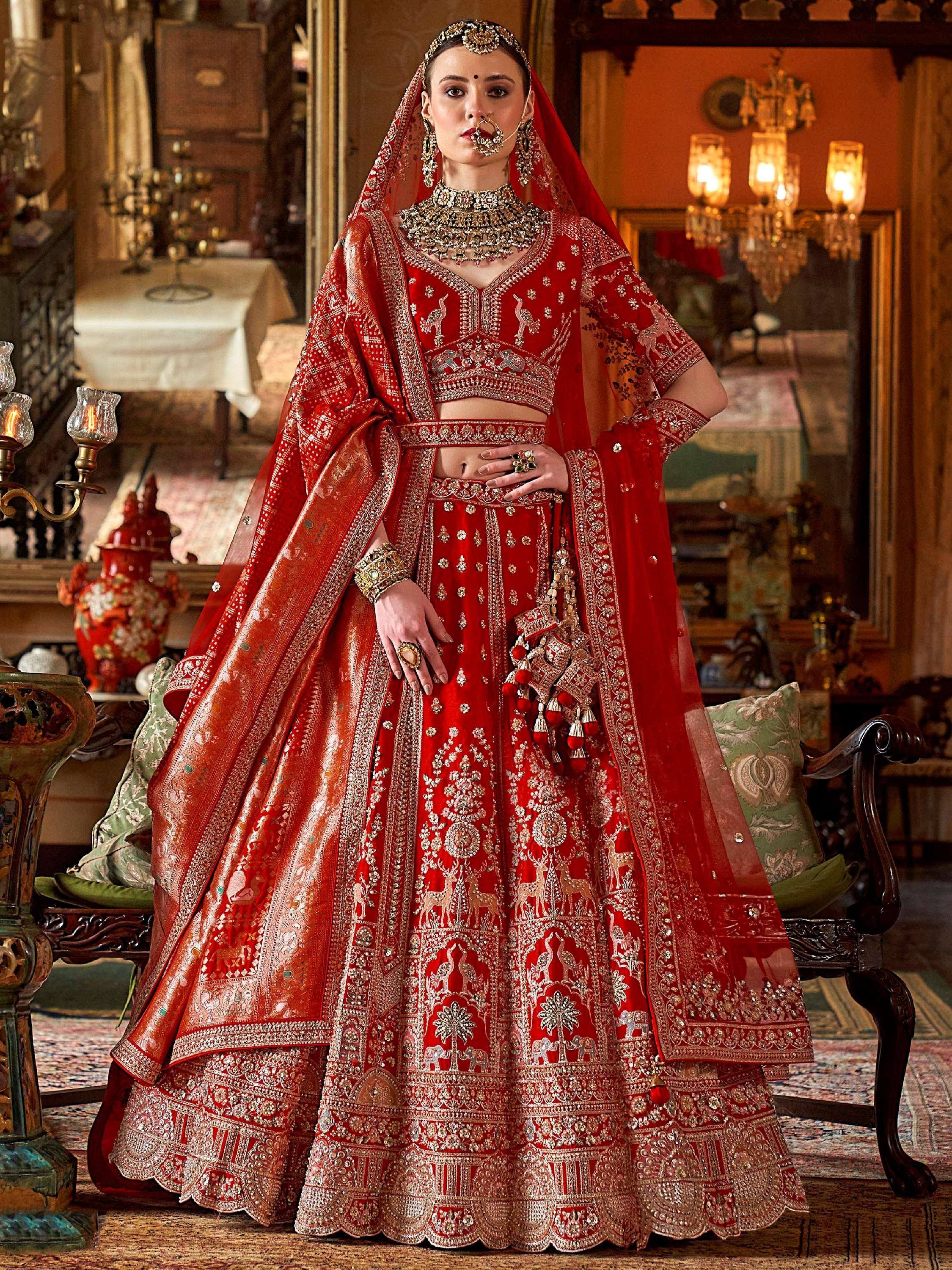 Red embroidered lehenga choli with gold detailing, traditional Indian bridal wear, heavy jewelry, and dupatta
