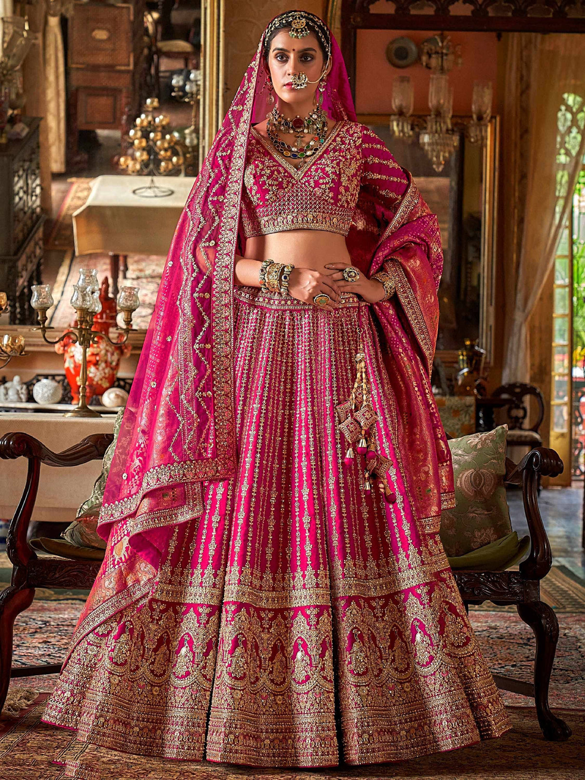 Fuchsia designer lehenga choli with gold embroidery, perfect for Indian weddings and festive occasions.