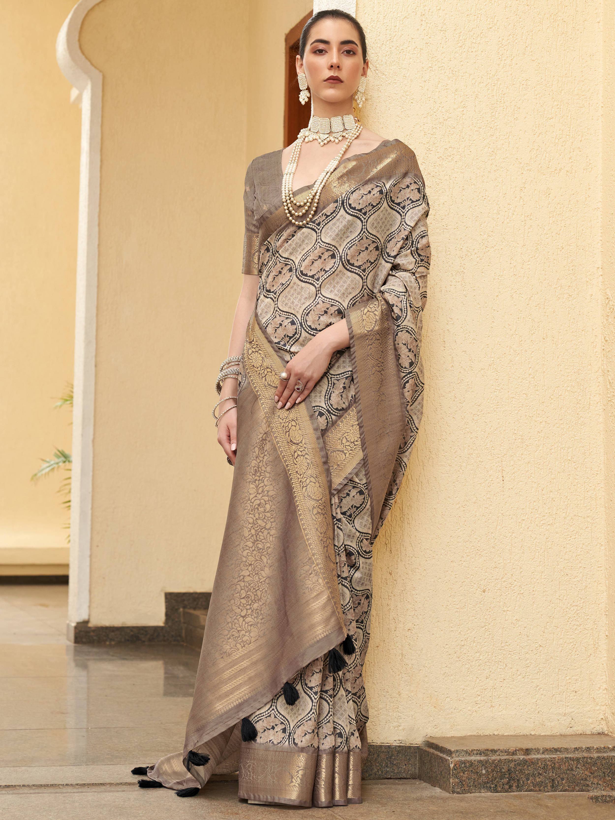 Elegant beige and black patterned saree with tassels, paired with pearl jewelry for Indian ethnic wear