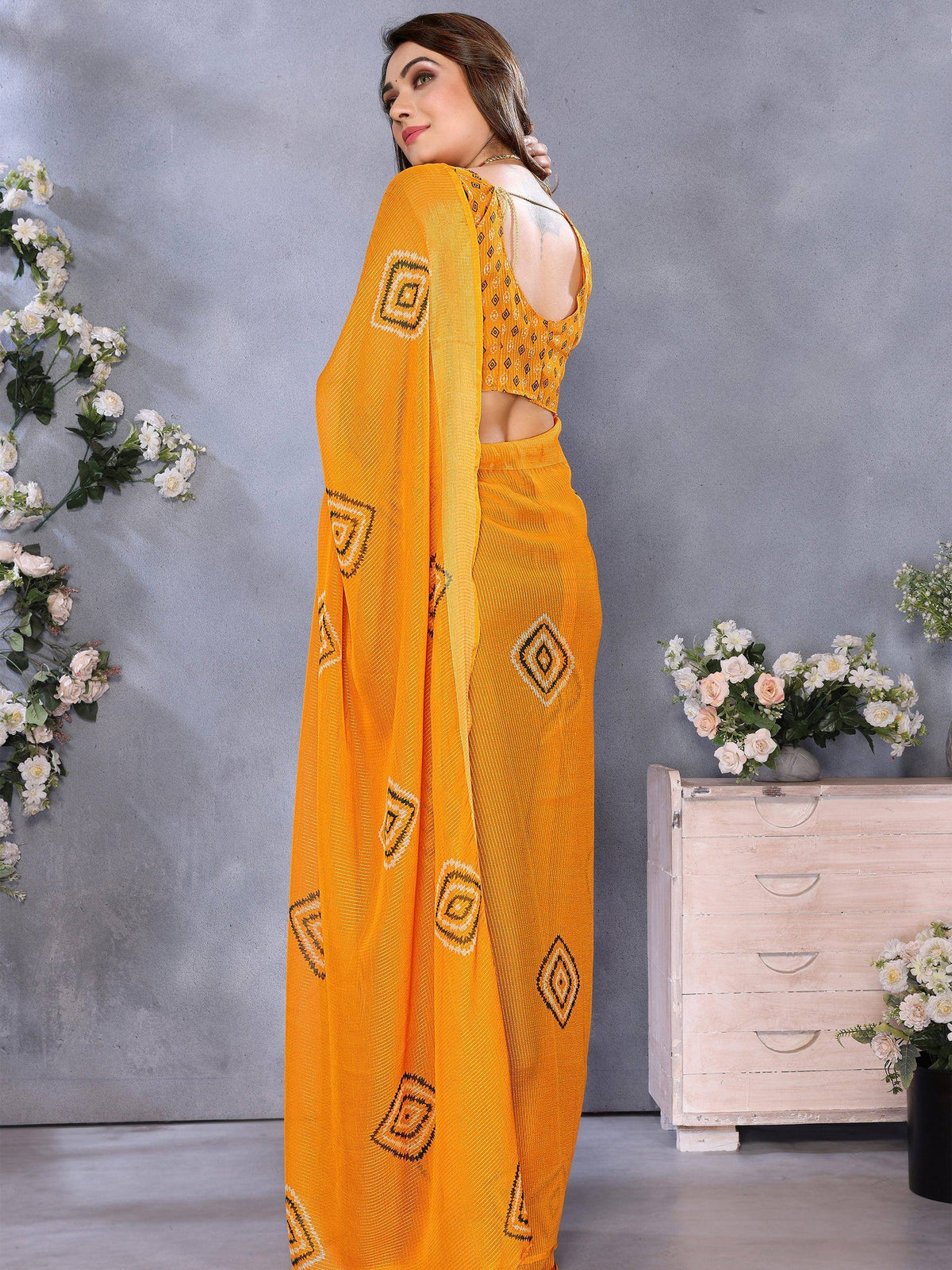 Vibrant yellow saree with geometric patterns, paired with a matching blouse for ethnic wear.