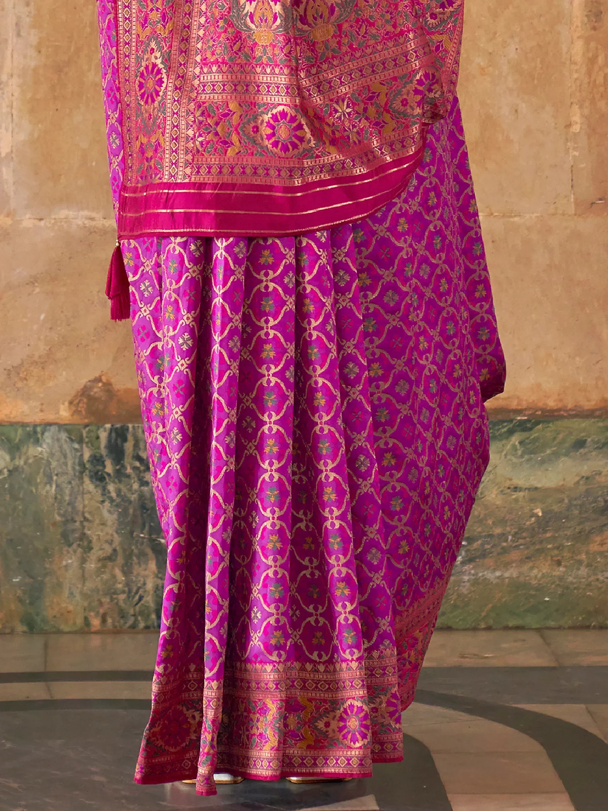 Vibrant pink and purple designer lehenga choli with intricate gold embroidery and floral motifs, perfect for Indian ethnic wear.