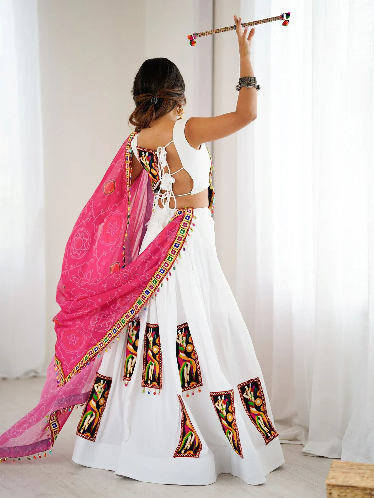 White embroidered lehenga choli with pink dupatta, showcasing ethnic Indian wear for festive occasions.
