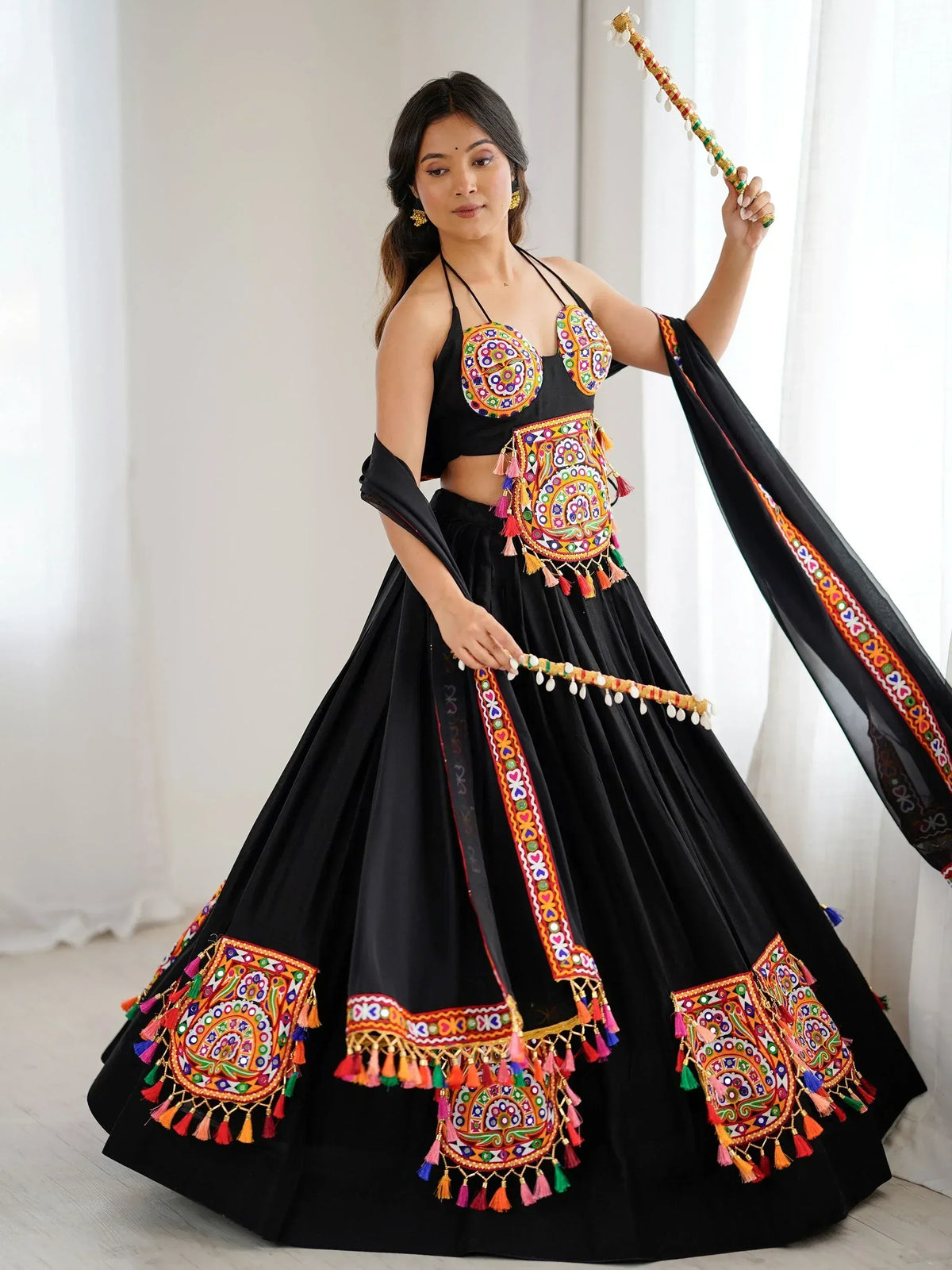 Black embroidered lehenga choli with colorful mirror work and tassels, perfect for Indian ethnic wear