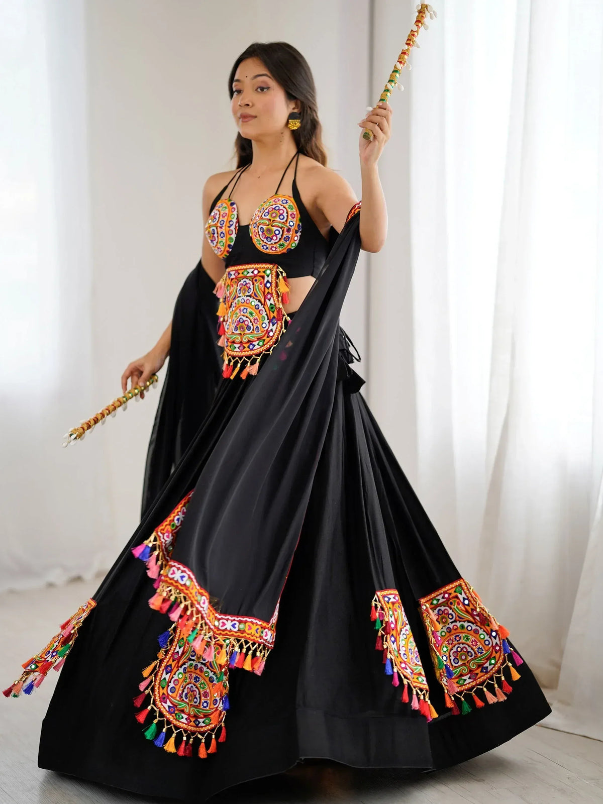 Black ethnic lehenga with colorful mirror work and tassels, paired with matching blouse and dupatta
